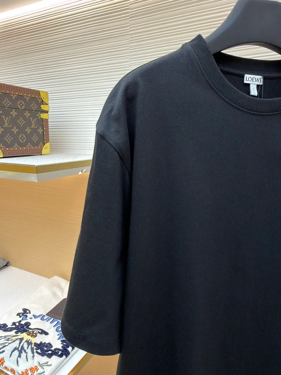 Loewe Cat Line Pattern Round Neck Short Sleeve ●Original version: Purchased and developed at 4330 ●Item number: 1681867-X85 ●Material: combed cotton fabric ●Technology: embroidery production ●Color: black ●Version: fitted version ●Weight: about 295 grams ●Size: XS-S-M-L ●Description: Made of 15S fine cotton plain fabric, 230g; with 32S double yarn thread, 300g. Plain weave fabric made from combed cotton fibers has a more orderly arrangement and higher density than ordinary cotton, so it has better texture and luster. 15S fine cotton plain fabric is a high-quality cotton fabric with the characteristics of softness, comfort, good breathability, and good durability. Anagram Embroidery Lucky Cat: The rice grain line embroidery process uses special ultra-fine embroidery thread and high-density stitching to create a pattern outline as delicate and continuous as grains. Its core feature lies in the precise arrangement of ultra-fine stitches, which require 12-15 stitches per centimeter to form full lines, and the edges present a handmade micro-waving effect. The fabric achieves a stroke-like gradient of thickness and flow. The overall pattern is light, breathable and smooth to the touch. It looks like a line outline from a distance, but the texture of interwoven fibers can be seen up close. It is especially suitable for expressing delicate details such as logo outlines and geometric borders. Anagram embroidery: Using three-dimensional embroidery technology, the logo clearly restores the spacing curve. The mercerized embroidery thread with luster is selected, combined with complex embroidery needlework and fine detail processing to create a three-dimensional relief embroidery effect. Classic trademark letter design, fine embroidery and dense stitching, clear font and strong sense of lines and three-dimensionality. The overall wiring is straight and delicate, the fabric is comfortable and soft, and the color is consistent without color difference. It can be matched with the same style to create a fashionable look and control various occasions. Customized accessories, complete with three standards, same style for men and women!