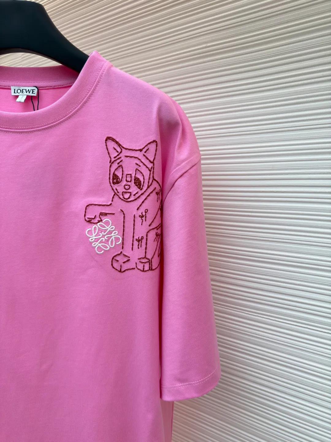 Loewe Cat Line Pattern Round Neck Short Sleeve ●Original version: Purchased and developed at 4330 ●Item number: 1681866-X85 ●Material: combed cotton fabric ●Technology: embroidery production ●Color: pink ●Version: fitted version ●Weight: about 285 grams ●Size: XS-S-M-L ●Description: Made of 15S fine cotton plain fabric, 230g; with 32S double yarn thread, 300g. Plain weave fabric made from combed cotton fibers has a more orderly arrangement and higher density than ordinary cotton, so it has better texture and luster. 15S fine cotton plain fabric is a high-quality cotton fabric with the characteristics of softness, comfort, good breathability, and good durability. Anagram Embroidery Lucky Cat: The rice grain line embroidery process uses special ultra-fine embroidery thread and high-density stitching to create a pattern outline as delicate and continuous as grains. Its core feature lies in the precise arrangement of ultra-fine stitches, which require 12-15 stitches per centimeter to form full lines, and the edges present a handmade micro-waving effect. The fabric achieves a stroke-like gradient of thickness and flow. The overall pattern is light, breathable and smooth to the touch. It looks like a line outline from a distance, but the texture of interwoven fibers can be seen up close. It is especially suitable for expressing delicate details such as logo outlines and geometric borders. Anagram embroidery: Using three-dimensional embroidery technology, the logo clearly restores the spacing curve. The mercerized embroidery thread with luster is selected, combined with complex embroidery needlework and fine detail processing to create a three-dimensional relief embroidery effect. Classic trademark letter design, fine embroidery and dense stitching, clear font and strong sense of lines and three-dimensionality. The overall wiring is straight and delicate, the fabric is comfortable and soft, and the color is consistent without color difference. It can be matched with the same style to create a fashionable look and control various occasions. Customized accessories, complete with three standards, same style for men and women!