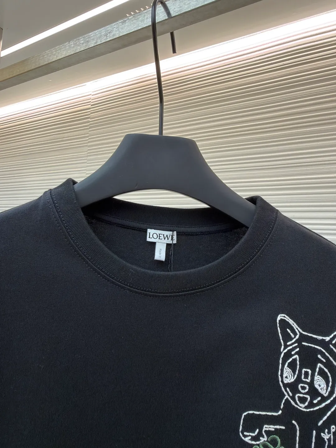 Loewe Cat Line Pattern Round Neck Short Sleeve ●Original version: Purchased and developed at 4330 ●Item number: 1681867-A00 ●Material: combed cotton fabric ●Technology: embroidery production ●Color: black ●Version: fitted version ●Weight: about 295 grams ●Size: XS-S-M-L ●Description: Made of 15S fine cotton plain fabric, 230g; with 32S double yarn thread, 300g. Plain weave fabric made from combed cotton fibers has a more orderly arrangement and higher density than ordinary cotton, so it has better texture and luster. 15S fine cotton plain fabric is a high-quality cotton fabric with the characteristics of softness, comfort, good breathability, and good durability. Anagram Embroidery Lucky Cat: The rice grain line embroidery process uses special ultra-fine embroidery thread and high-density stitching to create a pattern outline as delicate and continuous as grains. Its core feature lies in the precise arrangement of ultra-fine stitches, which require 12-15 stitches per centimeter to form full lines, and the edges present a handmade micro-waving effect. The fabric achieves a stroke-like gradient of thickness and flow. The overall pattern is light, breathable and smooth to the touch. It looks like a line outline from a distance, but the texture of interwoven fibers can be seen up close. It is especially suitable for expressing delicate details such as logo outlines and geometric borders. Anagram embroidery: Using three-dimensional embroidery technology, the logo clearly restores the spacing curve. The mercerized embroidery thread with luster is selected, combined with complex embroidery needlework and fine detail processing to create a three-dimensional relief embroidery effect. Classic trademark letter design, fine embroidery and dense stitching, clear font and strong sense of lines and three-dimensionality. The overall wiring is straight and delicate, the fabric is comfortable and soft, and the color is consistent without color difference. It can be matched with the same style to create a fashionable look and control various occasions. Customized accessories, complete with three standards, same style for men and women!