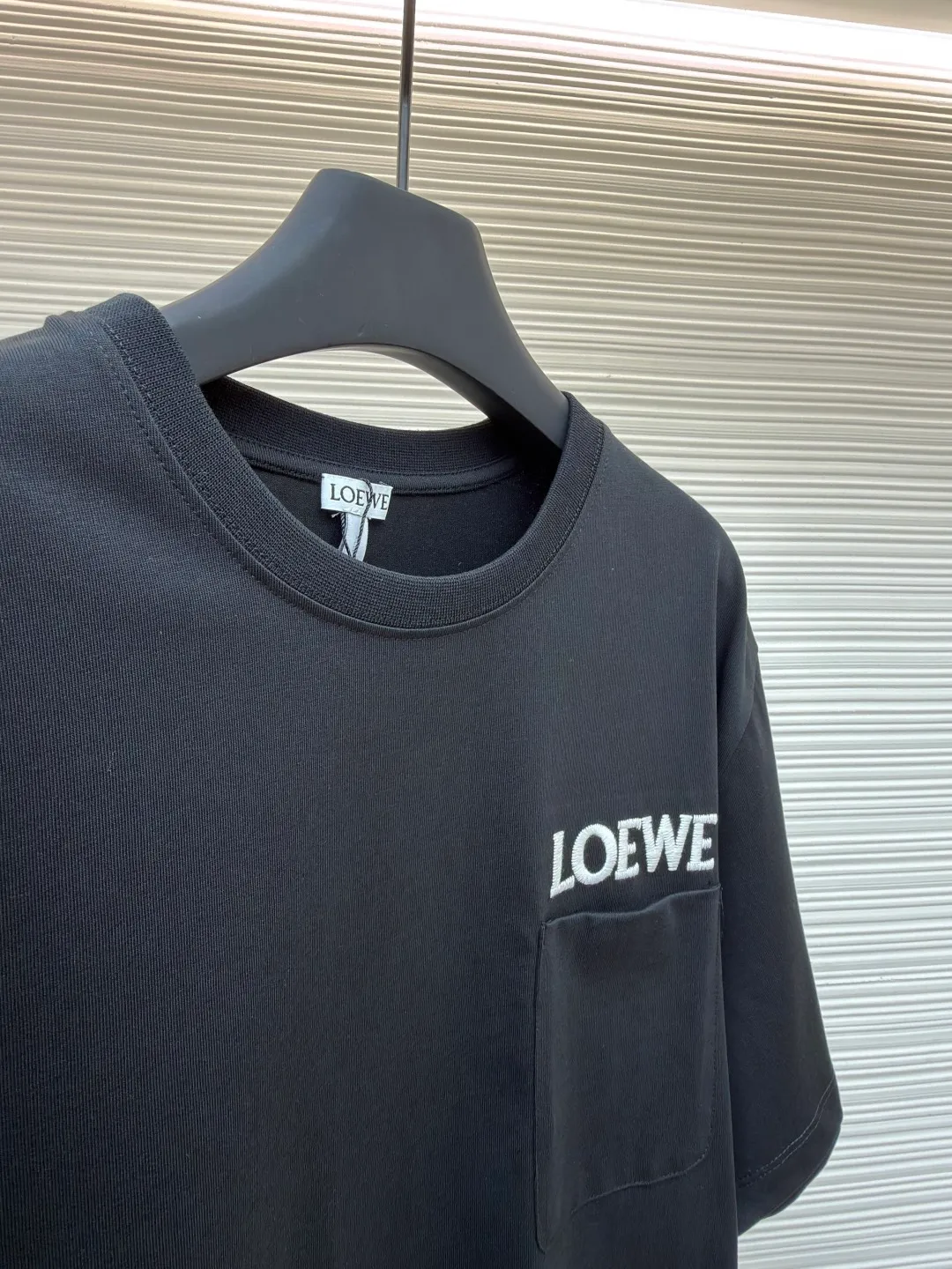 Loewe Patch Pocket Round Neck Short Sleeve ●Original version: Purchased and developed by 3621 ●Item number: 1681853-A00 ●Material: combed cotton fabric ●Technology: embroidery production ●Color: black ●Version: fitted version ●Weight: about 265 grams ●Size: XS-S-M-L ●Description: Made of 15S fine cotton plain fabric, 230g; with 32S double yarn thread, 300g. Plain weave fabric made from combed cotton fibers has a more orderly arrangement and higher density than ordinary cotton, so it has better texture and luster. 15S fine cotton plain fabric is a high-quality cotton fabric with the characteristics of softness, comfort, good breathability, and good durability. Matching the specific color and thick thread material, single-needle lock embroidery is mainly used, and the stitches of this embroidery are fine. The craftsmanship is exquisite. The edge of the pattern not only makes the embroidery appear smooth, but also the stitches are arranged neatly and evenly, without exposing the ground or overlapping. The embroidery uses thick lines to outline the letter pattern, and the thick lines create a more three-dimensional texture. Thick thread embroidery has the rough feel of hand embroidery, and the overall effect is three-dimensional and the texture is delicate, creating a dual texture in terms of look and feel. The overall wiring is straight and delicate, the fabric is comfortable and soft, and the color is consistent without color difference. It can be matched with the same style to create a fashionable look and control various occasions. Customized accessories, complete with three standards, same style for men and women!