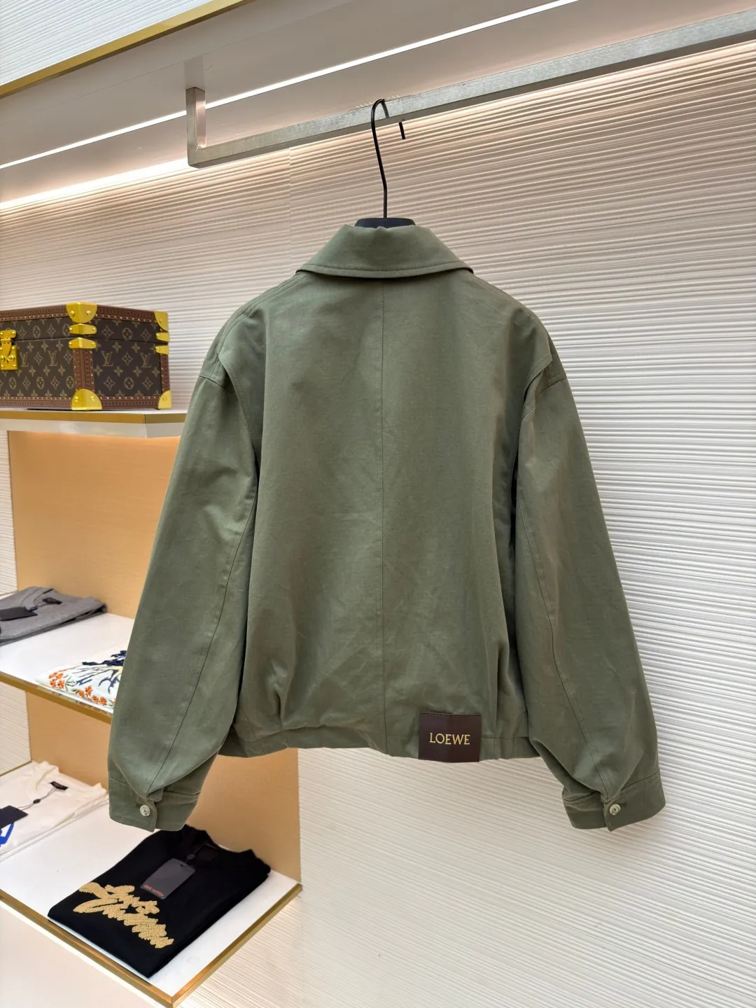 Loewe Army Green Trimmed Jacket ●Original version: Purchased and developed for 20900 ●Item number: 1682098-B40 ●Fabric: High weight dyed cotton satin fabric ●Technology: Leather patch production ●Color: Military green ●Version: Fitted version ●Weight: about 745 grams ●Size: 46-48-50-52 ●Description: Made of 100% pure cotton cloth, the fabric is dyed in the original color. The leather label is made of real cowhide composite, and the surface is stamped with gold powder to create the brand logo. The waist belt is made of multi-layer composite, and the oil edge design presents a different visual effect. Medium weight garment-dyed cotton satin jacket with gathered front and decorative contrasting belt. * Regular fit, standard length * Classic collar * Front zip closure, button cuffs * Seamed pockets, internal welt pockets * Fully lined * Anagram embroidery on chest, LOEWE embossed leather patch on back. The overall wiring is straight and delicate, the fabric is comfortable and soft, and the color is consistent without color difference. It can be matched with the same style to create a fashionable look and control various occasions. Customized accessories, complete with three standards, same style for men and women!