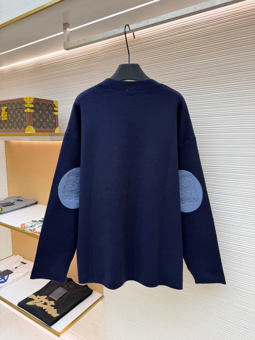 Loewe padded 3D embroidered crew neck sweater ●Original version: purchased and developed by 15168 ●Item number: 1681872-A85 ●Fabric: wool blended fabric ●Technology: 3D embroidery production ●Color: navy blue ●Version: fitted version ●Weight: about 565 grams ●Size: S-M-L-XL ●Description: Made of wool blended fabric, mainly 96% wool, combined with 3% nylon and 1% spandex. The main body of wool ensures the warmth and comfort of the clothing. The addition of a small amount of nylon and spandex significantly improves the elasticity and wear resistance. The ribbed decorative parts are made of 100% wool, which further enhances the texture and wearing experience. Tightly fasten the fabric and cushioning material to the frame of the embroidery machine. The embroidery machine uses sparse stitches along the pattern of the cushion layer to outline the filling area of the pattern. Then it runs the pattern of the overlay layer, using dense stitches to perfectly cover the foam cushion layer, thus forming a slightly raised Anagram embroidery, which is soft and soft to the touch. The full and thick thread layer plays a protective role and greatly improves its wear resistance. Add detergent and preliminarily rinse the bulk goods at a water temperature of about 35 degrees to remove impurities during the production process. The protease is then used to gently digest the hairiness on the surface, thereby reducing the tendency to pilling from the source, improving the feel, retaining softness, and eliminating irritation. Finally, after dehydration and drying, the dimensional and shape stability is improved. The overall wiring is straight and delicate, the fabric is comfortable and soft, and the color is consistent without color difference. It can be matched with the same style to create a fashionable look and control various occasions. Customized accessories, complete with three standards, same style for men and women!