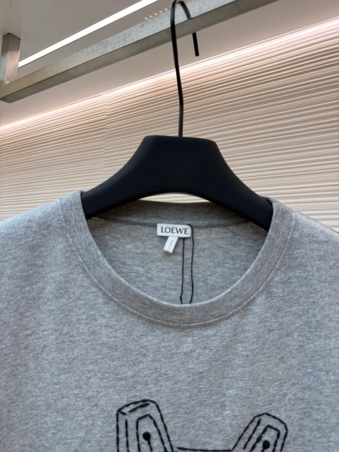 Loewe Stone Cat Round Neck Long Sleeve ●Original version: Purchased and developed by 5148 ●Item number: 1681939-A15 ●Fabric: Cotton jersey fabric ●Technology: Rice grain line embroidery production ●Color: gray ●Version: Fitted version ●Weight: about 250 grams ●Size: High-count combed cotton yarn eliminates most of the short hairiness through compact spinning process, making the yarn smoother and stronger. The woven fabric structure is extremely dense, flat and soft, with excellent anti-pilling ability and durability, while retaining the natural advantages of pure cotton, which is breathable and skin-friendly. The neckline is made of 32S 1x1 rib with a weight of 300g. The finer yarn count creates a more delicate and tight thread, which provides better resilience and anti-deformation than ordinary ribs, ensuring that the neckline can still remain stiff after being put on and taken off many times. The rice grain line embroidery process uses special ultra-fine embroidery thread and high-density stitching to create a pattern outline as delicate and continuous as grains. Its core feature lies in the precise arrangement of ultra-fine stitches, which require 12-15 stitches per centimeter to form full lines, and the edges present a handmade micro-waving effect. The fabric achieves a stroke-like gradient of thickness and flow. The overall pattern is light, breathable and smooth to the touch. It looks like a line outline from a distance, but the texture of interwoven fibers can be seen up close. It is especially suitable for expressing delicate details such as logo outlines and geometric borders. Anagram embroidery: Using three-dimensional embroidery technology, the logo clearly restores the spacing curve. The mercerized embroidery thread with luster is selected, combined with complex embroidery needlework and fine detail processing to create a three-dimensional relief embroidery effect. Classic trademark letter design, fine embroidery and dense stitching, clear font and strong sense of lines and three-dimensionality. The overall wiring is straight and delicate, the fabric is comfortable and soft, and the color is consistent without color difference. It can be matched with the same style to create a fashionable look and control various occasions. Customized accessories, complete with three standards, same style for men and women!