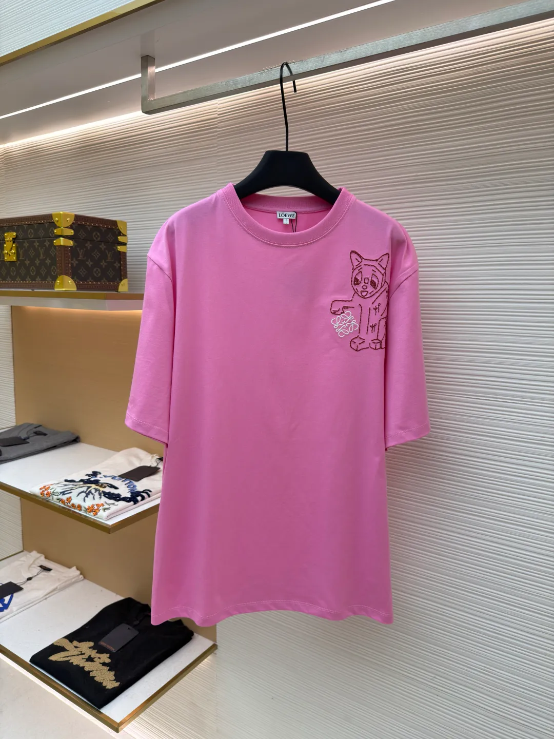 Loewe Cat Line Pattern Round Neck Short Sleeve ●Original version: Purchased and developed at 4330 ●Item number: 1681866-A00 ●Material: combed cotton fabric ●Technology: embroidery production ●Color: pink ●Version: fitted version ●Weight: about 285 grams ●Size: XS-S-M-L ●Description: Made of 15S fine cotton plain fabric, 230g; with 32S double yarn thread, 300g. Plain weave fabric made from combed cotton fibers has a more orderly arrangement and higher density than ordinary cotton, so it has better texture and luster. 15S fine cotton plain fabric is a high-quality cotton fabric with the characteristics of softness, comfort, good breathability, and good durability. Anagram Embroidery Lucky Cat: The rice grain line embroidery process uses special ultra-fine embroidery thread and high-density stitching to create a pattern outline as delicate and continuous as grains. Its core feature lies in the precise arrangement of ultra-fine stitches, which require 12-15 stitches per centimeter to form full lines, and the edges present a handmade micro-waving effect. The fabric achieves a stroke-like gradient of thickness and flow. The overall pattern is light, breathable and smooth to the touch. It looks like a line outline from a distance, but the texture of interwoven fibers can be seen up close. It is especially suitable for expressing delicate details such as logo outlines and geometric borders. Anagram embroidery: Using three-dimensional embroidery technology, the logo clearly restores the spacing curve. The mercerized embroidery thread with luster is selected, combined with complex embroidery needlework and fine detail processing to create a three-dimensional relief embroidery effect. Classic trademark letter design, fine embroidery and dense stitching, clear font and strong sense of lines and three-dimensionality. The overall wiring is straight and delicate, the fabric is comfortable and soft, and the color is consistent without color difference. It can be matched with the same style to create a fashionable look and control various occasions. Customized accessories, complete with three standards, same style for men and women!