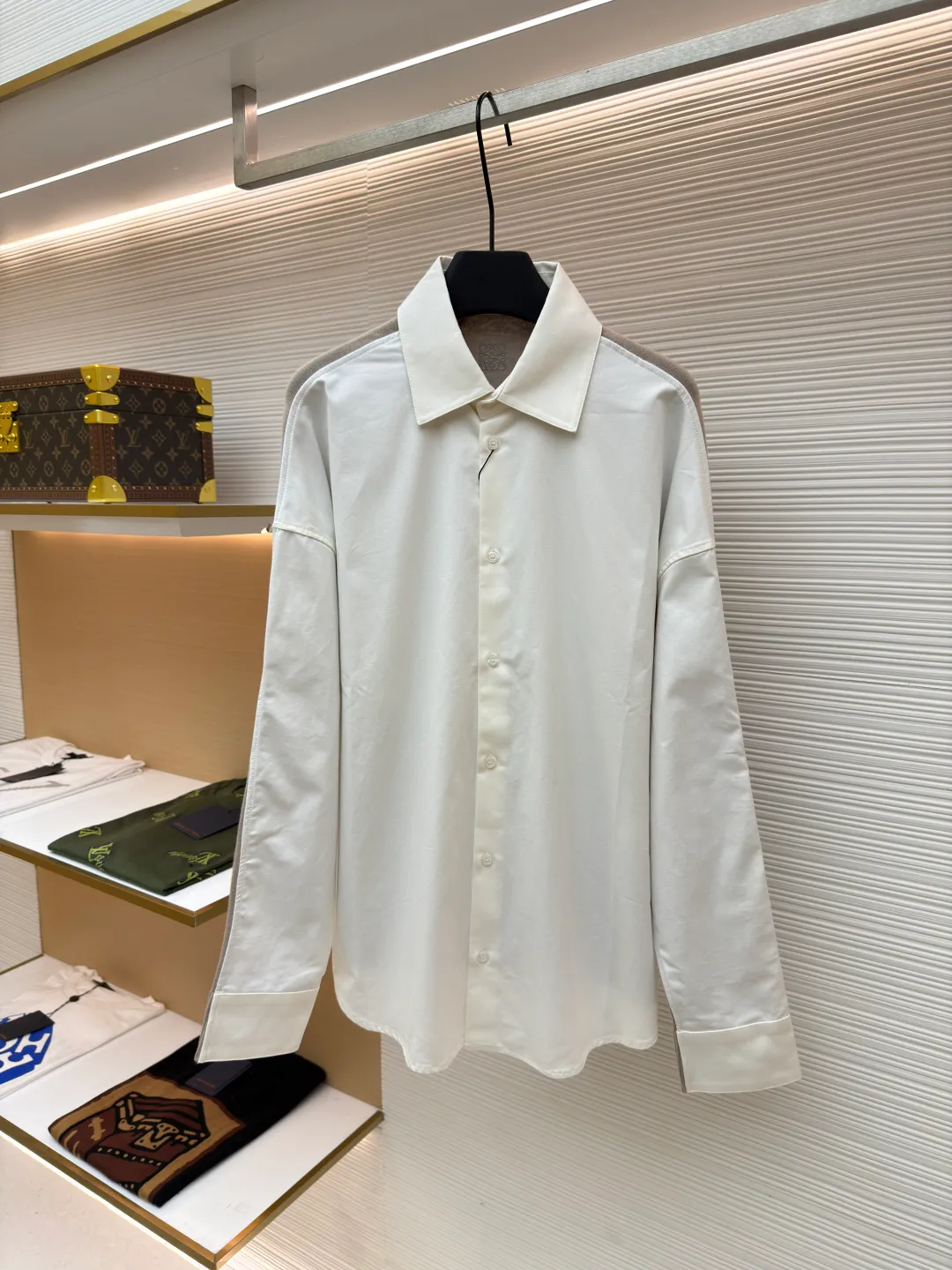 LOEWE cotton and knitted spliced shirt ●Original version: purchased and developed by 12479 ●Item number: 1680887-B50 ●Fabric: high-count cotton yarn fabric ●Technology: mechanical embroidery production ●Version: fitted version ●Weight: about 350 grams ●Size: 36-38-40-42 ●Description: The front panel is made of high-count cotton yarn through a weaving process with high warp density and low weft density to make a light and thin fabric with excellent breathability. The surface is smooth and flat, and feels as smooth as silk. At the same time, it retains the natural skin-friendly properties of cotton, making it snug and comfortable without any strange feeling. Because the warp yarns are closely arranged, the surface of the fabric shows longitudinal texture and soft luster, enhancing the visual sense of luxury. The back panel is woven with extremely fine wool yarn through high-count spinning technology to make a fabric with moderate density. It feels soft and skin-friendly, and has a delicate velvet feel on the surface. Wool fiber has a natural hollow structure, which can lock in still air and form an excellent thermal insulation layer. Even if it is light and thin, it has a good thermal insulation effect. Under the back collar, the high-precision calculation system of the computerized embroidery machine controls the coordinated operation of the machine head, needle bar, and thread spool. The fabric frame moves accurately in the horizontal and vertical directions to form a stitch track. The upper and lower thread tensions are adjusted to ensure that the stitches are smooth and free of floating threads, forming anagram embroidery with an error of ±0.1mm. The overall wiring is straight and delicate, the fabric is comfortable and soft, and the color is consistent without color difference. It can be matched with the same style to create a fashionable look and control various occasions. Customized accessories, complete with three standards, same style for men and women!