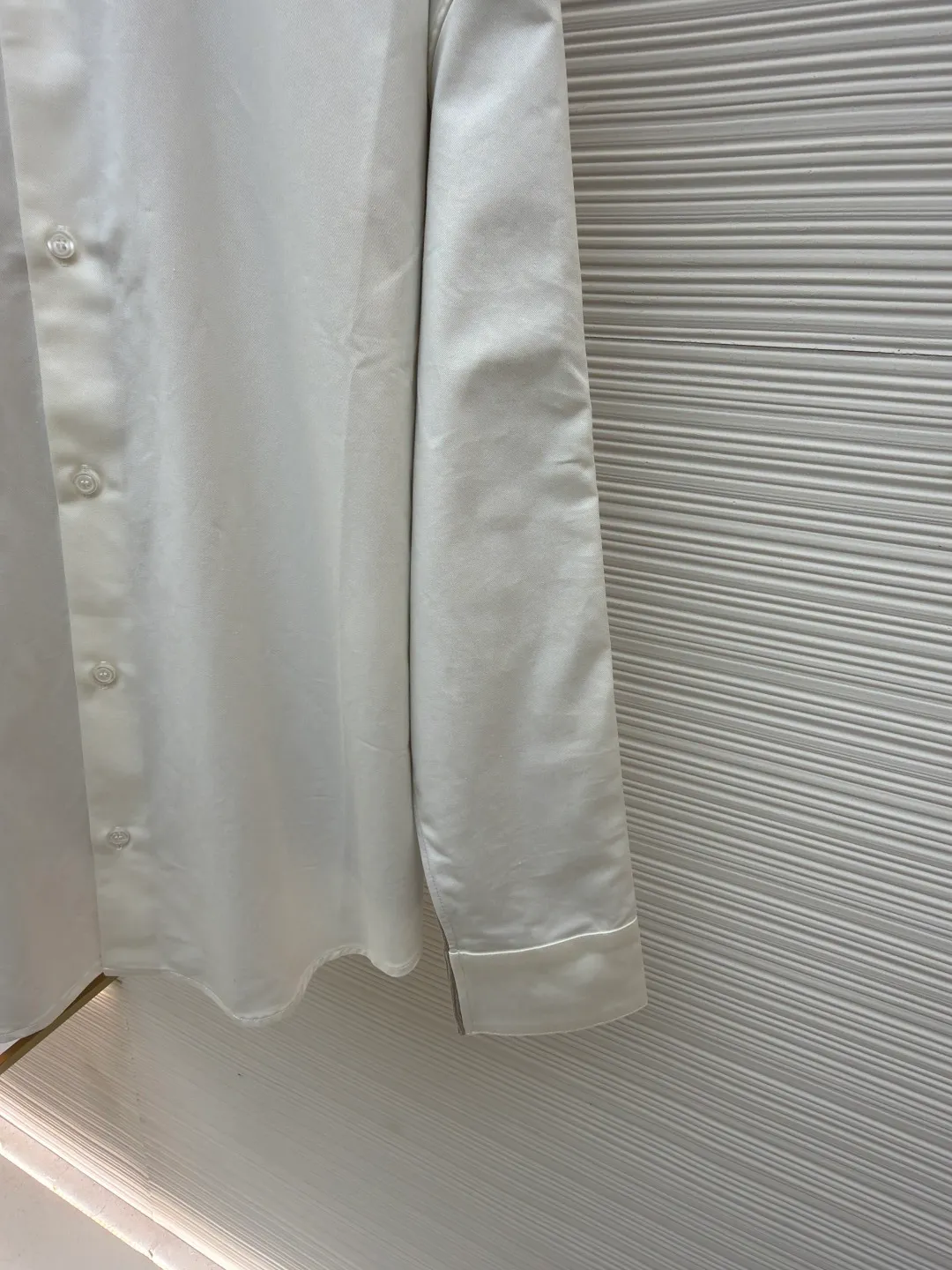 LOEWE cotton and knitted spliced shirt ●Original version: purchased and developed by 12479 ●Item number: 1680887-B50 ●Fabric: high-count cotton yarn fabric ●Technology: mechanical embroidery production ●Version: fitted version ●Weight: about 350 grams ●Size: 36-38-40-42 ●Description: The front panel is made of high-count cotton yarn through a weaving process with high warp density and low weft density to make a light and thin fabric with excellent breathability. The surface is smooth and flat, and feels as smooth as silk. At the same time, it retains the natural skin-friendly properties of cotton, making it snug and comfortable without any strange feeling. Because the warp yarns are closely arranged, the surface of the fabric shows longitudinal texture and soft luster, enhancing the visual sense of luxury. The back panel is woven with extremely fine wool yarn through high-count spinning technology to make a fabric with moderate density. It feels soft and skin-friendly, and has a delicate velvet feel on the surface. Wool fiber has a natural hollow structure, which can lock in still air and form an excellent thermal insulation layer. Even if it is light and thin, it has a good thermal insulation effect. Under the back collar, the high-precision calculation system of the computerized embroidery machine controls the coordinated operation of the machine head, needle bar, and thread spool. The fabric frame moves accurately in the horizontal and vertical directions to form a stitch track. The upper and lower thread tensions are adjusted to ensure that the stitches are smooth and free of floating threads, forming anagram embroidery with an error of ±0.1mm. The overall wiring is straight and delicate, the fabric is comfortable and soft, and the color is consistent without color difference. It can be matched with the same style to create a fashionable look and control various occasions. Customized accessories, complete with three standards, same style for men and women!