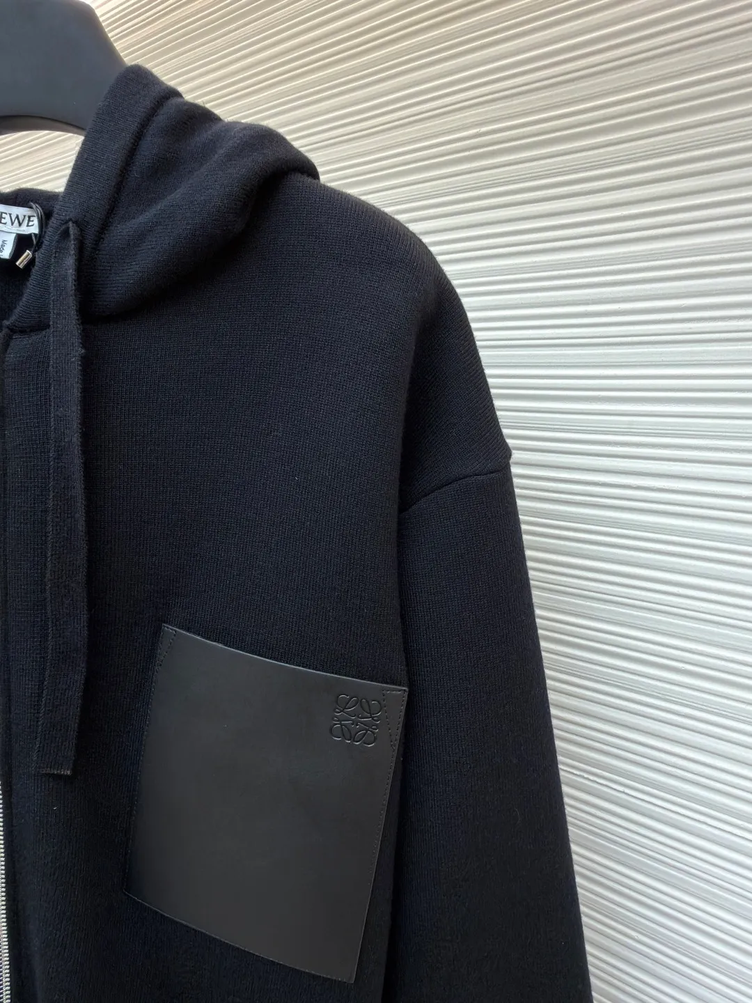 Loewe leather label pocket knitted zipper hoodie ●Original version: purchased and developed for 15900 ●Item number: 1681811-B15 ●Fabric: wool blended fabric ●Technology: knitted patch production ●Color: black ●Version: fitted version ●Weight: about 1025 grams ●Size: S-M-L-XL ●Description: Made of 55% merino wool and woven with a 14-needle imported machine. The entire garment weighs about 960-1000 grams. The upper body shape is very three-dimensional. The thermal insulation effect is also very good when worn outside. The leather label is made of double-layer composite imitation cowhide, and the process adopts three-dimensional relief embossing technology, and the Anagram icon is embossed with high temperature. Laser positioning and wiring, each piece of clothing passes multi-layer quality inspection before being shipped. The zippers are made of No. 5 bright white electroplated zippers, the LOEWE brand logo is electroplated and engraved on the sides, and the pull teeth are made of Euler electroplated teeth. Garment washing - removal of wool impurities - color fixation - fixed fit medium weight wool hooded sweatshirt. *Regular fit, standard length*Double side seams*Hooded collar*Leather chest patch pocket*Front zip closure*Ribbed cuffs and hem*Chest pocket trim. The overall wiring is straight and delicate, the fabric is comfortable and soft, and the color is consistent without color difference. It can be matched with the same style to create a fashionable look and control various occasions. Customized accessories, complete with three standards, same style for men and women!