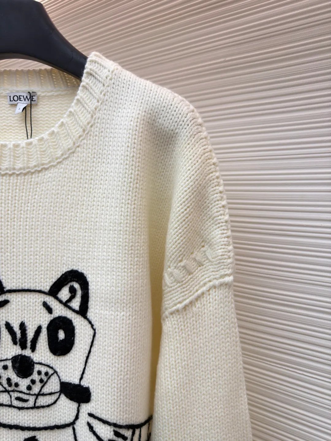 Loewe cat star round neck embroidered long-sleeved sweater ●Original version: purchased and developed by 19451 ●Item number: 1682139-C05 ●Fabric: wool blended fabric ●Technology: knitted embroidery production ●Color: white ●Version: fitted version ●Weight: about 740 grams ●Size: S-M-L-XL ●Description: This Loewe cat embroidered totem thick needle knitted sweater is made of imported merino wool woolen yarn and woven with an 8-needle thick needle plain knitting process. The yarn has been pre-washed and milled and anti-pilling, giving the garment a soft and waxy feel and a crisp texture. The loose shoulder style is formed in one go by an Italian computerized flat machine, which reduces stitching and makes it more neat. The cat totem on the front uses a combination of three-dimensional chain embroidery + satin embroidery, using high-tenacity black cotton blended embroidery thread. It is completed by hand stitch by stitch by senior embroidery workers. The outline of the pattern is smooth and full of three-dimensionality. The bottom layer of embroidery is paved with non-woven interlining to prevent the embroidery thread from pulling and causing the body to deform. The neckline, cuffs and hem are all designed with double-ply ribbing and built-in elastic spandex yarn. It has excellent resilience after high-temperature setting treatment. The low-temperature steam process is used during manual ironing to retain the natural texture and silhouette of the wool yarn to the greatest extent. The overall wiring is straight and delicate, the fabric is comfortable and soft, and the color is consistent without color difference. It can be matched with the same style to create a fashionable look and control various occasions. Customized accessories, complete with three standards, same style for men and women!