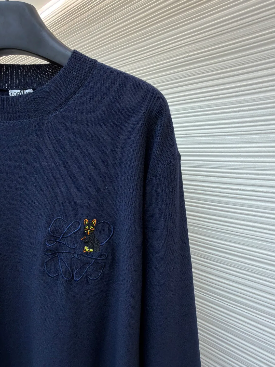 Loewe jersey stitched crew neck embroidered sweater ●Original version: purchased and developed by 8395 ●Item number: 1682517-A45 ●Fabric: wool fabric ●Technology: knitted embroidery production ●Color: navy blue ●Version: fitted version ●Weight: about 305 grams ●Size: S-M-L-XL ●Description: This LOEWE navy blue knitted sweater is knitted with high-quality merino wool blended yarn and uses plain knitting technology to create the body. The fabric is fine, soft, waxy and elastic, with both warmth retention and breathability, and is not prone to pilling or snagging. The brand's classic embroidery pattern on the left chest is made of the same color and gold embroidery thread, and is made with fine appliqué technology. The pattern is three-dimensional and vivid, with dense stitching, forming a low-key texture contrast with the knitted base, highlighting the brand's recognition. The neckline is a classic round neck design, with double-needle reinforced hemming technology and a custom-made threaded collar, making it durable and not prone to loosening. The cuffs and hem are designed with ribbed edges, with moderate elasticity to fit the body shape. The overall cut is a loose silhouette, with straight and fine stitching lines. Customized accessories and three labels are complete. The details and craftsmanship show the level of luxury. It is suitable for casual daily and light business wear scenarios. The overall wiring is straight and delicate, the fabric is comfortable and soft, and the color is consistent without color difference. It can be matched with the same style to create a fashionable look and control various occasions. Customized accessories, complete with three standards, same style for men and women!