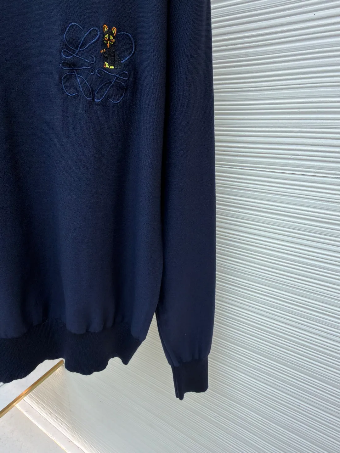 Loewe jersey stitched crew neck embroidered sweater ●Original version: purchased and developed by 8395 ●Item number: 1682517-A45 ●Fabric: wool fabric ●Technology: knitted embroidery production ●Color: navy blue ●Version: fitted version ●Weight: about 305 grams ●Size: S-M-L-XL ●Description: This LOEWE navy blue knitted sweater is knitted with high-quality merino wool blended yarn and uses plain knitting technology to create the body. The fabric is fine, soft, waxy and elastic, with both warmth retention and breathability, and is not prone to pilling or snagging. The brand's classic embroidery pattern on the left chest is made of the same color and gold embroidery thread, and is made with fine appliqué technology. The pattern is three-dimensional and vivid, with dense stitching, forming a low-key texture contrast with the knitted base, highlighting the brand's recognition. The neckline is a classic round neck design, with double-needle reinforced hemming technology and a custom-made threaded collar, making it durable and not prone to loosening. The cuffs and hem are designed with ribbed edges, with moderate elasticity to fit the body shape. The overall cut is a loose silhouette, with straight and fine stitching lines. Customized accessories and three labels are complete. The details and craftsmanship show the level of luxury. It is suitable for casual daily and light business wear scenarios. The overall wiring is straight and delicate, the fabric is comfortable and soft, and the color is consistent without color difference. It can be matched with the same style to create a fashionable look and control various occasions. Customized accessories, complete with three standards, same style for men and women!