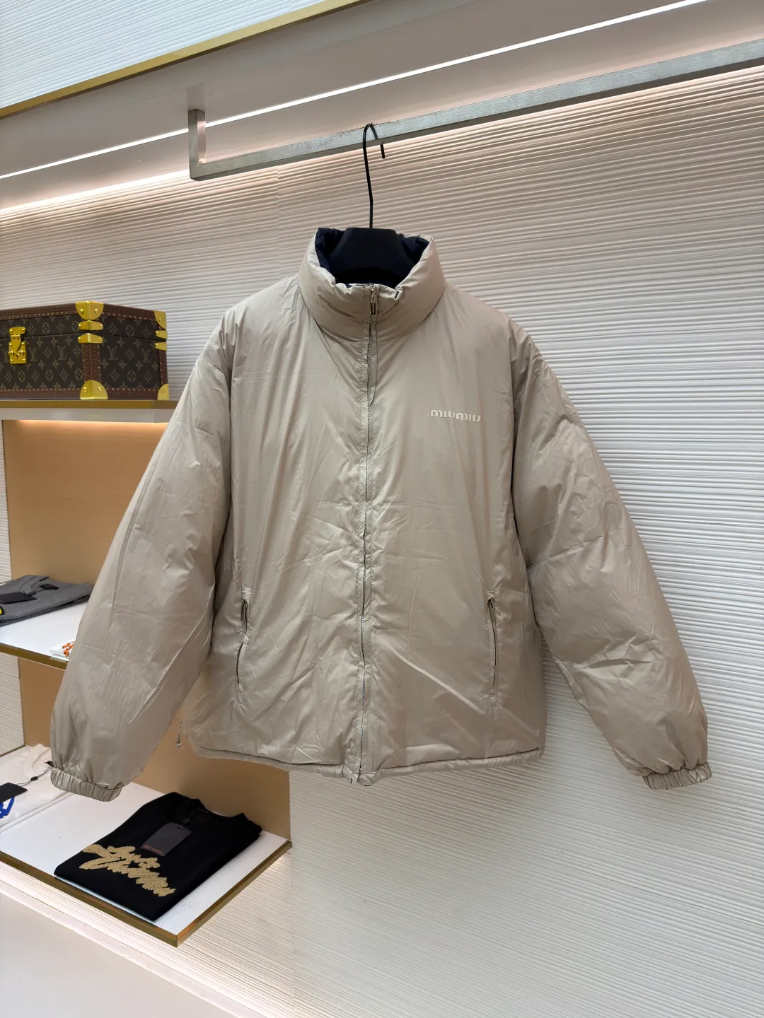 MIUMIU reversible stand collar down jacket ●Original version: purchased and developed by 21060 ●Item number: 1681385-D05 ●Fabric: white duck down fabric ●Technology: mechanical down filling ●Color: navy/khaki ●Version: fitted version ●Weight: about 675 grams ●Size: 36-38-40-42 ●Description: The filling is white duck down with 90% down content, which is one of the gold standards of down quality. "90% down content" means that the down content is extremely high and there are very few impurities such as feather stalks. The down tufts can capture more air and form an efficient thermal insulation layer, thus providing several times the loft and warmth of ordinary down while being lighter in weight. In the double-sided structure, ensuring that the down is evenly distributed between the two layers of fabric without clumping is the core challenge of the down filling process. The stand-up collar design not only improves the neatness of the shape, but also enhances the windproof and warm performance of the neck. Its internal structure needs to be stiff enough to maintain a three-dimensional shape, while at the same time ensuring the comfort of contact with the skin. The precision stitching in conjunction with the overall design not only plays a role in fixing the down and preventing displacement, but the uniformity, tension and pattern of the stitches have become important decorative elements, reflecting rigorous industrial aesthetics. The overall wiring is straight and delicate, the fabric is comfortable and soft, and the color is consistent without color difference. It can be matched with the same style to create a fashionable look and control various occasions. Customized accessories, complete with three standards, same style for men and women!