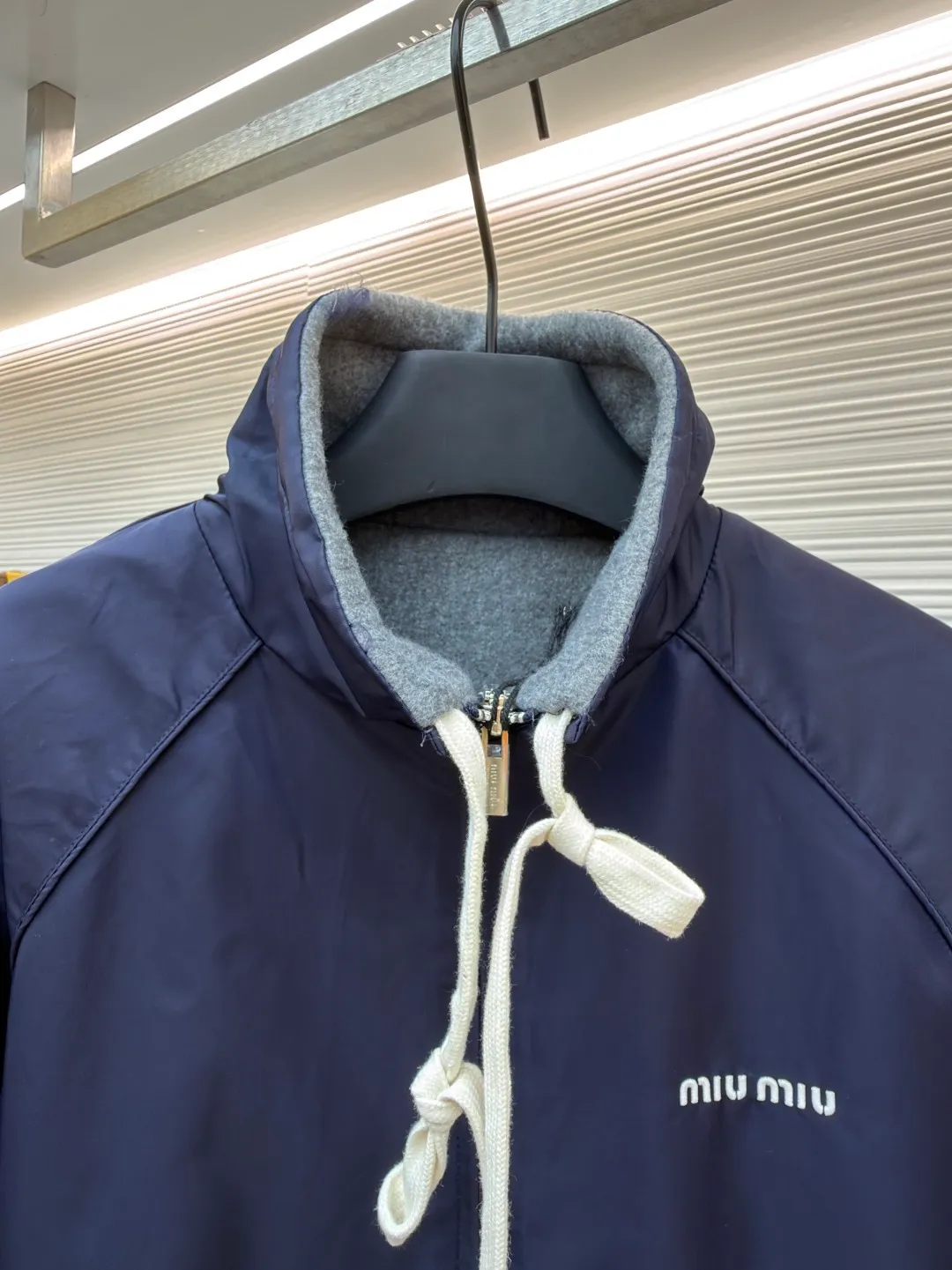 MIUMIU reversible technical fabric and fleece jacket ●Original version: 28200 purchase and development ●Item number: 1682256-C00 ●Fabric: wool blended anti-static plush fabric ●Technology: high temperature pre-shrunk production ●Color: blue/grey ●Version: fitted version ●Weight: about 890 grams ●Size: 36-38-40-42 ●Description: This Miu The Miu navy jacket is made of high-density polyester fabric, which has been treated with water-repellent treatment. The surface has a fine matte texture and has good windproof performance. The body is cut with raglan sleeves, and the three-dimensional patterning technology is used to make the shoulder lines more ergonomic, and there is no sense of restraint when moving. The neckline is spliced ​​with gray fleece lining, which is reinforced with double-needle hemming technology. The drawstring is made of natural cotton rope and has been brushed. The texture is soft and waxy and not easy to deform. The front is equipped with a customized metal zipper, and the smoothness of the gear rail has been tested multiple times. The zipper puller and brand logo are both made by laser engraving. The ribbed edges on the hem and cuffs are made of spandex blended material and are pre-shrunk to prevent them from loosening after long-term wear. The overall stitching uses dual processes of flat turning and overlocking. The stitching is even and fine, reaching the high standard of 12 stitches per inch, ensuring both a stiff silhouette and durability. The overall wiring is straight and delicate, the fabric is comfortable and soft, and the color is consistent without color difference. It can be matched with the same style to create a fashionable look and control various occasions. Customized accessories, complete with three standards, same style for men and women!