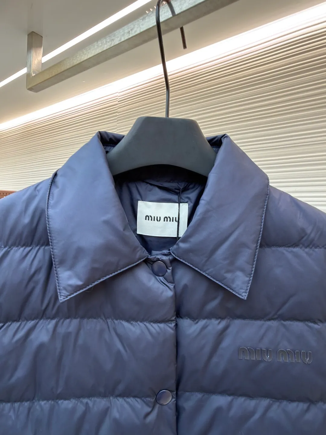 MIUMIU rib down lapel vest ●Original version: Purchased and developed for 12999 ●Item number: 1681785-C05 ●Fabric: goose down fabric ●Technology: mechanical down filling ●Color: navy blue ●Version: fitted version ●Weight: about 350 grams ●Size: 36-38-40-42 ●Description: Down anti-drilling liner is a kind of inner liner specially used for down jackets. It is usually made of high-density, anti-drilling down and good breathability materials. It can effectively prevent down from drilling out while maintaining the warmth and breathability of down jackets. Goose down filling is a high-quality filling in down jackets. It is rich in down, and because goose down has a higher loft, it can lock in more air, making the down jacket warmer. Down is soft and delicate. It feels soft and comfortable when worn on the human body, without the foreign body feeling caused by other fillings. After aurora printing, the pattern containing special additives is heat-pressed and transferred to the fabric in the form of a film, and the process parameters are adjusted to give it a slightly aged texture. This not only achieves the decorative purpose of the brand logo, but also avoids the stiffness often found in new technology fabrics because of its retro treatment of details. The design of the shirt collar allows the vest to increase its versatility. The snap closure provides a faster, smoother and more even force-on and take-off experience, especially when worn as an inner layer, making it less likely to snag with outer clothing. The elastic drawstring hem can be tightened by the drawstring, effectively preventing cold air from pouring in from the bottom and locking in body heat. The flap pocket is a classic outdoor functional design that prevents rain, wind and snow from entering the pocket, and is equipped with buttons for a more durable and quieter closure.