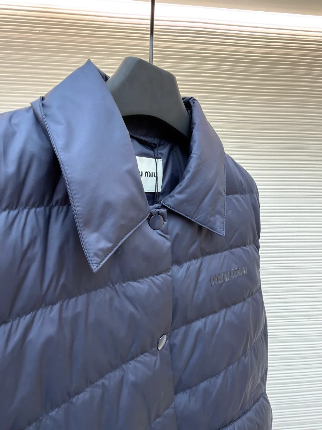 MIUMIU rib down lapel vest ●Original version: Purchased and developed for 12999 ●Item number: 1681785-C05 ●Fabric: goose down fabric ●Technology: mechanical down filling ●Color: navy blue ●Version: fitted version ●Weight: about 350 grams ●Size: 36-38-40-42 ●Description: Down anti-drilling liner is a kind of inner liner specially used for down jackets. It is usually made of high-density, anti-drilling down and good breathability materials. It can effectively prevent down from drilling out while maintaining the warmth and breathability of down jackets. Goose down filling is a high-quality filling in down jackets. It is rich in down, and because goose down has a higher loft, it can lock in more air, making the down jacket warmer. Down is soft and delicate. It feels soft and comfortable when worn on the human body, without the foreign body feeling caused by other fillings. After aurora printing, the pattern containing special additives is heat-pressed and transferred to the fabric in the form of a film, and the process parameters are adjusted to give it a slightly aged texture. This not only achieves the decorative purpose of the brand logo, but also avoids the stiffness often found in new technology fabrics because of its retro treatment of details. The design of the shirt collar allows the vest to increase its versatility. The snap closure provides a faster, smoother and more even force-on and take-off experience, especially when worn as an inner layer, making it less likely to snag with outer clothing. The elastic drawstring hem can be tightened by the drawstring, effectively preventing cold air from pouring in from the bottom and locking in body heat. The flap pocket is a classic outdoor functional design that prevents rain, wind and snow from entering the pocket, and is equipped with buttons for a more durable and quieter closure.