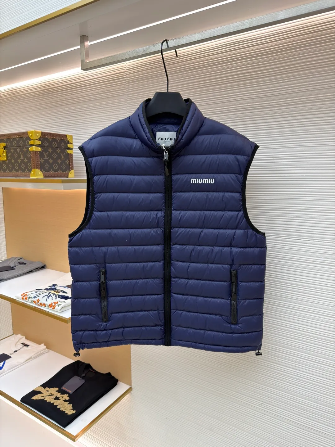 MIUMIU embroidered down vest ●Original version: purchased and developed by 15870 ●Item number: 1681121-B70 ●Fabric: high-quality down fabric ●Technology: embroidery production ●Version: fitted version ●Weight: about 380 grams ●Size: 34-36-38 ●Description: High-end nylon fabric made of high-count polyamide fiber, known for its excellent tensile strength and wear resistance. Its good flexibility makes the fabric less prone to wrinkles and keeps it crisp and stylish for a long time. The tight weave effectively blocks the invasion of cold wind and locks in the warm air generated by the down layer. The high-density nylon surface forms a certain lotus leaf effect, making it difficult for small water droplets to penetrate, keeping the interior dry and effectively extending the service life of the down. It uses 90 national standard high-quality down, with a filling capacity of 140 grams. It has high fluffiness, strong warmth retention, lightness and no burden, and can easily cope with cold weather. Whether it is urban commuting or outdoor leisure, this down jacket has become an indispensable luxury item in the winter wardrobe with its excellent performance and simple design. The logo adopts imported machine embroidery technology, uses advanced computer control systems and precision mechanical components to achieve mimiu embroidery operations, with high precision, smooth and delicate lines. The overall wiring is straight and delicate, the fabric is comfortable and soft, and the color is consistent without color difference. It can be matched with the same style to create a fashionable look and control various occasions. Customized accessories, complete with three standards, same style for men and women!