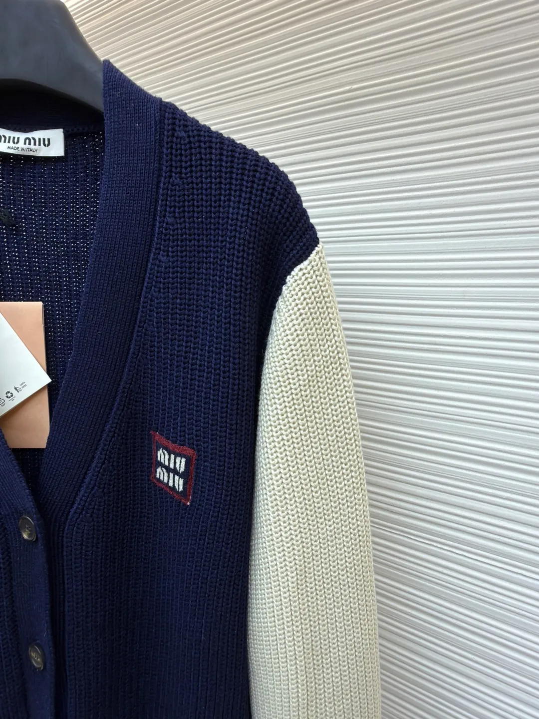 MIUMIU College Style Chest Logo Jacquard Sweater ●Original version: Purchased and developed for 26900 ●Item number: 1681494-A65 ●Fabric: wool blended fabric ●Technology: Knitted ●Color: off-white/navy blue ●Version: Fitted version ●Weight: about 785g ●Size: 42-44-46 ●Description: Made of 40% sheep soft 15% wool 45% cotton blended fabric, original dyed royal blue. Use 7 stitches to knit a multi-piece sewing plate. It uses horn buttons, each button has irregular horn patterns, and the chest label is made of pure cotton custom jacquard MiuMiu. Tennis-inspired details accent this cashmere and wool-blend cardigan. The distinctive ribbed pattern and oversized shape create a casual and elegant style. The overall wiring is straight and delicate, the fabric is comfortable and soft, and the color is consistent without color difference. It can be matched with the same style to create a fashionable look and control various occasions. Customized accessories, complete with three standards, same style for men and women!