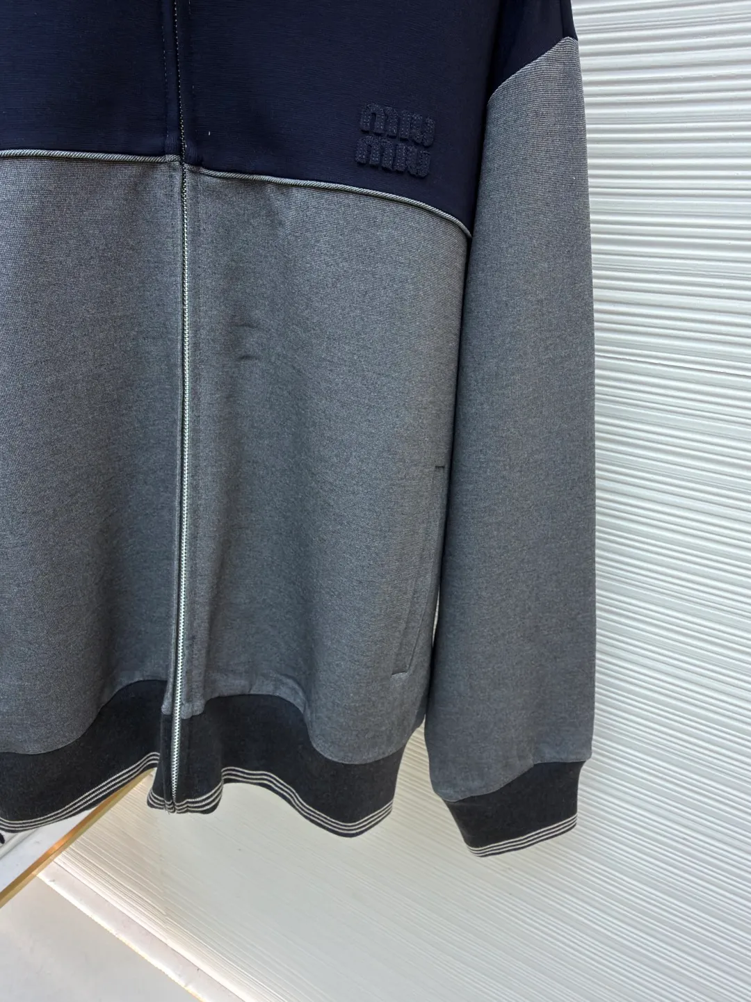 MIUMIU embroidered logo zipper jacket ●Item number: 1682174-B70 ●Material: mercerized wool fabric ●Technology: laser burning ●Color: gray ●Version: fitted version ●Weight: about 990 grams ●Size: S-M-L-XL ●Description: Customized mercerized wool, delicate as silk, warm to the touch When the quiet blue of the deep sea meets the calm gray of the rocks It exudes a sense of high-end and hides restrained aesthetic ideas. It has a neat sports silhouette. The iconic Miu Miu embroidered logo of the same color is embellished on the chest. It is low-key but can hardly hide the identity mark. It is hidden in the public and visible in the mind. The street-style zipper sweatshirt silhouette is disassembled to present an architectural three-dimensional sense of depth. Suit attendance has become the focus of fashion pioneers. Laser burning process is an advanced process that uses laser technology for logo engraving. The laser is projected onto the surface of the material, causing the material to be locally and rapidly heated to melt to form the Miu Miu logo. The position and shape can be precisely controlled. Adopt imported machine embroidery technology, use advanced computer control systems and precision mechanical components to achieve Miu Miu logo embroidery operations with high precision. The lines are smooth and delicate, and the fabrics have been sand-washed. The texture is better, not easy to deform, not easy to shrink, not easy to fade, and maintains long-term beauty. The overall wiring is straight and delicate, the fabric is comfortable and soft, and the color is consistent without color difference. It can be matched with the same style to create a fashionable look and control various occasions. Customized accessories, complete with three standards, same style for men and women!