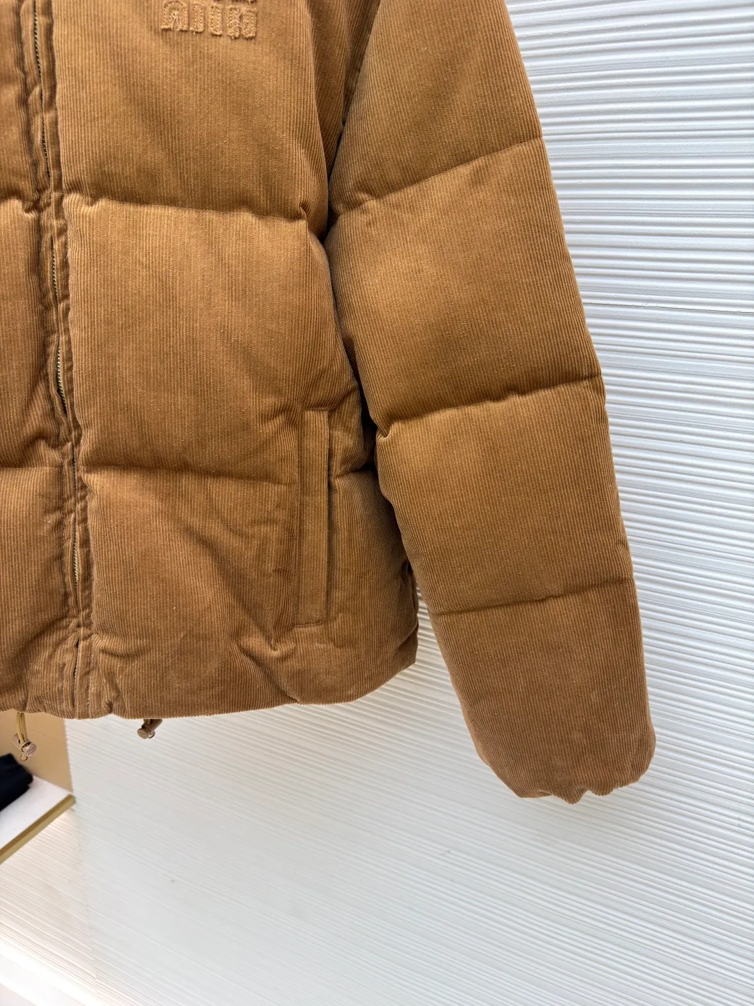 MIUMIU Leather collar patch embroidered corduroy down jacket [Women's clothing] ●Original version: purchased and developed by 22509 ●Item number: 1681469-D90 ●Fabric: white duck down fabric ●Technology: patch production ●Color: brown ●Version: fitted version ●Weight: about 1075 ●Size: S-M-L ●Description: Corduroy fabric made of 100% cotton fiber. The surface shows clear longitudinal velvet strips, and the concave and convex three-dimensional muscles are formed through the cutting process, giving the fabric a unique visual layering. The cotton fiber itself is moisture-absorbent and breathable, and combined with the suede structure of corduroy, it feels thick and soft. The air layer formed between the velvet strips can effectively isolate cold air, store body temperature, and improve the cold resistance effect. The lining is made of high-density weaving of 100% polyester fiber, with a thickness of 0.08mm to avoid increasing the overall weight and making it smooth to wear. The high-density weaving structure forms a wind resistance layer to protect the thermal efficiency of the thermal layer from loss. It can withstand the expansion pressure of down and prevent deformation and damage after long-term use. It uses 90 white duck down with a weight of 220g to ensure excellent thermal insulation performance. After strict screening and processing, the velvet is not easy to get drilled, ensuring durability. The overall wiring is straight and delicate, the fabric is comfortable and soft, and the color is consistent without color difference. It can be matched with the same style to create a fashionable look and control various occasions. Customized accessories, complete with three standards, same style for men and women!