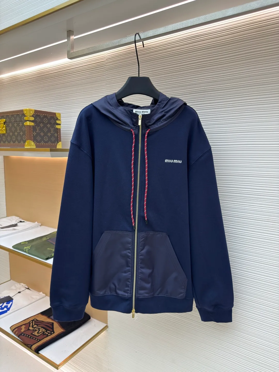 MIUMIU embroidered hooded sweatshirt ●Original version: purchased and developed by 13979 ●Item number: 1680807-B05 ●Fabric: fish scale fabric ●Technology: embroidery production ●Version: fitted version ●Weight: about 790 grams ●Size: S-M-L-XL ●Description: A single-sided fish-scale fabric woven with cotton as the base. The front is a smooth knitted surface, and the skin-contacting surface is formed into three-dimensional terry by the floating thread knitting technology of the knitting machine, which increases the fluffiness and has a delicate touch. The terry structure absorbs a large amount of water and evaporates quickly, so it is not easy to loosen and deform after repeated washing. The hat body and side pockets are made of nylon fabric, which is wear-resistant and has good wind resistance as the hat body. The 2*2 ribs formed by alternating longitudinal rows of front coils and longitudinal rows of back coils are still very elastic and have wide textures that fit the wrists and waist without a sense of restraint. The gaps between the coils allow air circulation without losing warmth. By actively interfering with the shrinkage potential of cotton fibers, the fabric is able to transition from changeable to stable, improving dimensional stability while being less prone to deformation and wrinkles. The high-precision calculation program system of the computerized embroidery machine controls the movement of the embroidery frame in the X/Y direction. At the same time, the needle shuttles up and down to embroider according to the set path. It automatically completes thread trimming, thread jumping and other actions to form a stitch track. It automatically adjusts the upper and lower thread tension to ensure that the stitches are smooth and free of floating threads, forming a high-precision letter pattern. The overall wiring is straight and delicate, the fabric is comfortable and soft, and the color is consistent without color difference. It can be matched with the same style to create a fashionable look and control various occasions. Customized accessories, complete with three standards, same style for men and women!