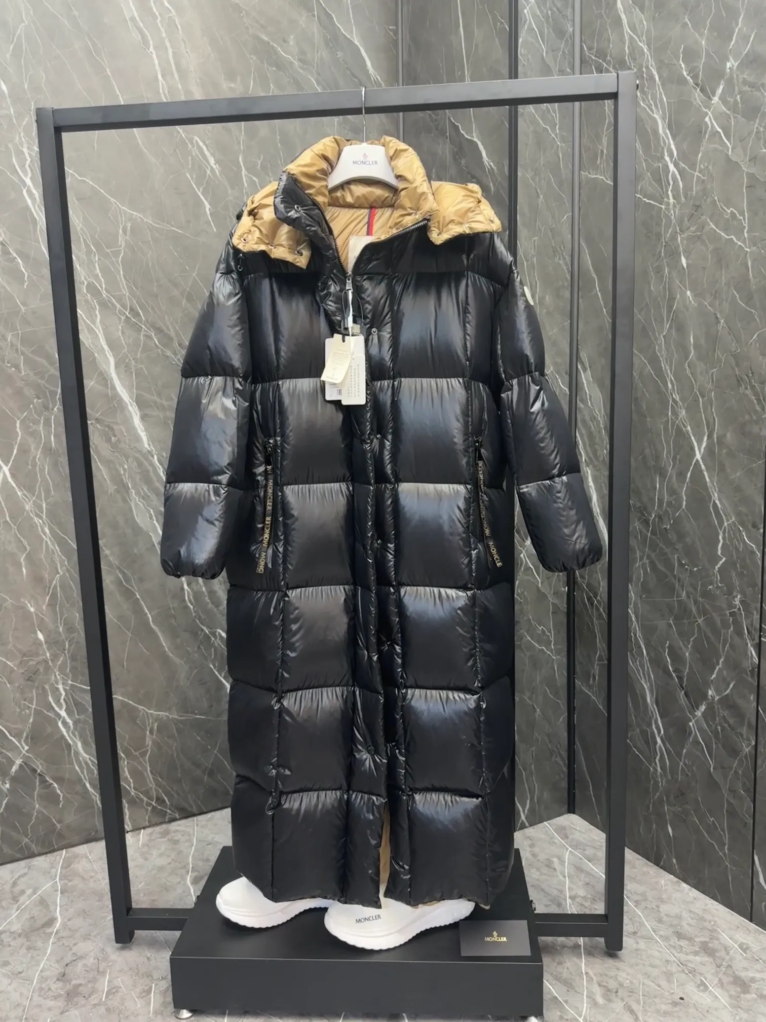 Special down  Parnaiba's long down jacket features graphic details and bold color blocking in signature patented nylon. The eye-catching design features large grille quilting and contrasting lining. The removable hood and adjustable hem make it easy to personalize the style, and the color-blocked pattern highlights the highly recognizable Moncler vibe. Details •Made from nylon laqué fabric •Contrast nylon laqué lining •Detachable hood with zipper and drawstring •Zip closure with black patented snap fastener ��Zip pocket Size: 0-4. Original runs large. D98108078950