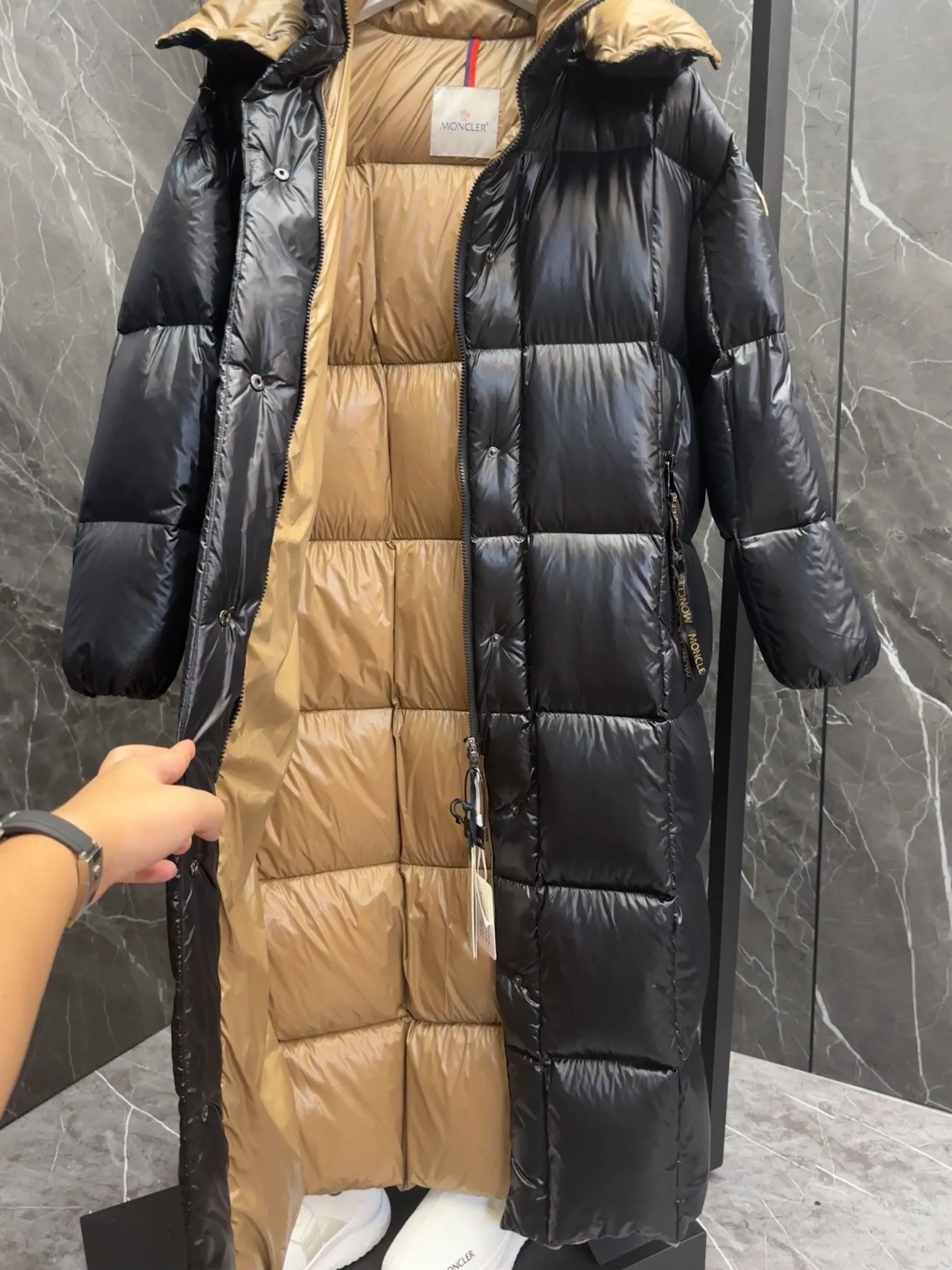 Special down  Parnaiba's long down jacket features graphic details and bold color blocking in signature patented nylon. The eye-catching design features large grille quilting and contrasting lining. The removable hood and adjustable hem make it easy to personalize the style, and the color-blocked pattern highlights the highly recognizable Moncler vibe. Details •Made from nylon laqué fabric •Contrast nylon laqué lining •Detachable hood with zipper and drawstring •Zip closure with black patented snap fastener ��Zip pocket Size: 0-4. Original runs large. D98108078950