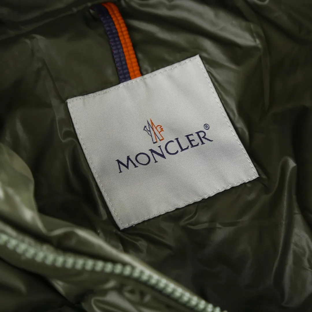 P900 MONCLER hooded brim quilted embroidered down jacket Fabric selection: The longue saison fabric is made of high-count polyamide fiber, which is known for its excellent tensile strength and lightness. Its good flexibility makes the fabric less prone to wrinkles and keeps it crisp and stylish for a long time. The tight weave effectively blocks the invasion of cold wind and locks in the warm air generated by the down layer. The high-density nylon surface forms a certain lotus leaf effect, making it difficult for small water droplets to penetrate, keeping the interior dry and effectively extending the service life of the down.  Lining selection: High-density lining fabric made of ultra-fine denier, 0.08mm thickness to avoid increasing the overall weight and making it smooth to wear. The high-density woven structure forms a wind resistance layer to protect the thermal efficiency of the thermal layer from loss. It can also withstand the expansion pressure of down and prevent deformation and damage after long-term use.  Technology: The quilted letter logo on the brim uses contour quilting technology. The stitching is routed along the edge of the set outline, and the filler is compressed inside the letter graphic, so that the logo is three-dimensional and convex, and the pattern is clear.  High-quality filling: It is filled with 90% selected white duck down, weighing 210g, ensuring fluffy rebound, lightness and warmth.  Accessories: one-to-one customized zipper pendant, one-to-one customized badge, one-to-one customized three-label SIZE: 1 2 3 4