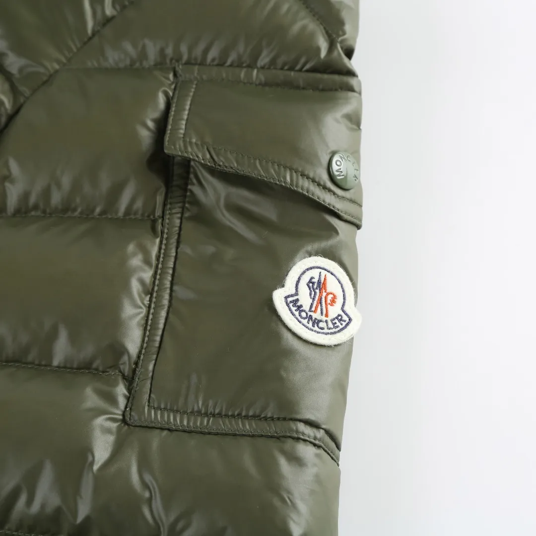 P900 MONCLER hooded brim quilted embroidered down jacket Fabric selection: The longue saison fabric is made of high-count polyamide fiber, which is known for its excellent tensile strength and lightness. Its good flexibility makes the fabric less prone to wrinkles and keeps it crisp and stylish for a long time. The tight weave effectively blocks the invasion of cold wind and locks in the warm air generated by the down layer. The high-density nylon surface forms a certain lotus leaf effect, making it difficult for small water droplets to penetrate, keeping the interior dry and effectively extending the service life of the down.  Lining selection: High-density lining fabric made of ultra-fine denier, 0.08mm thickness to avoid increasing the overall weight and making it smooth to wear. The high-density woven structure forms a wind resistance layer to protect the thermal efficiency of the thermal layer from loss. It can also withstand the expansion pressure of down and prevent deformation and damage after long-term use.  Technology: The quilted letter logo on the brim uses contour quilting technology. The stitching is routed along the edge of the set outline, and the filler is compressed inside the letter graphic, so that the logo is three-dimensional and convex, and the pattern is clear.  High-quality filling: It is filled with 90% selected white duck down, weighing 210g, ensuring fluffy rebound, lightness and warmth.  Accessories: one-to-one customized zipper pendant, one-to-one customized badge, one-to-one customized three-label SIZE: 1 2 3 4