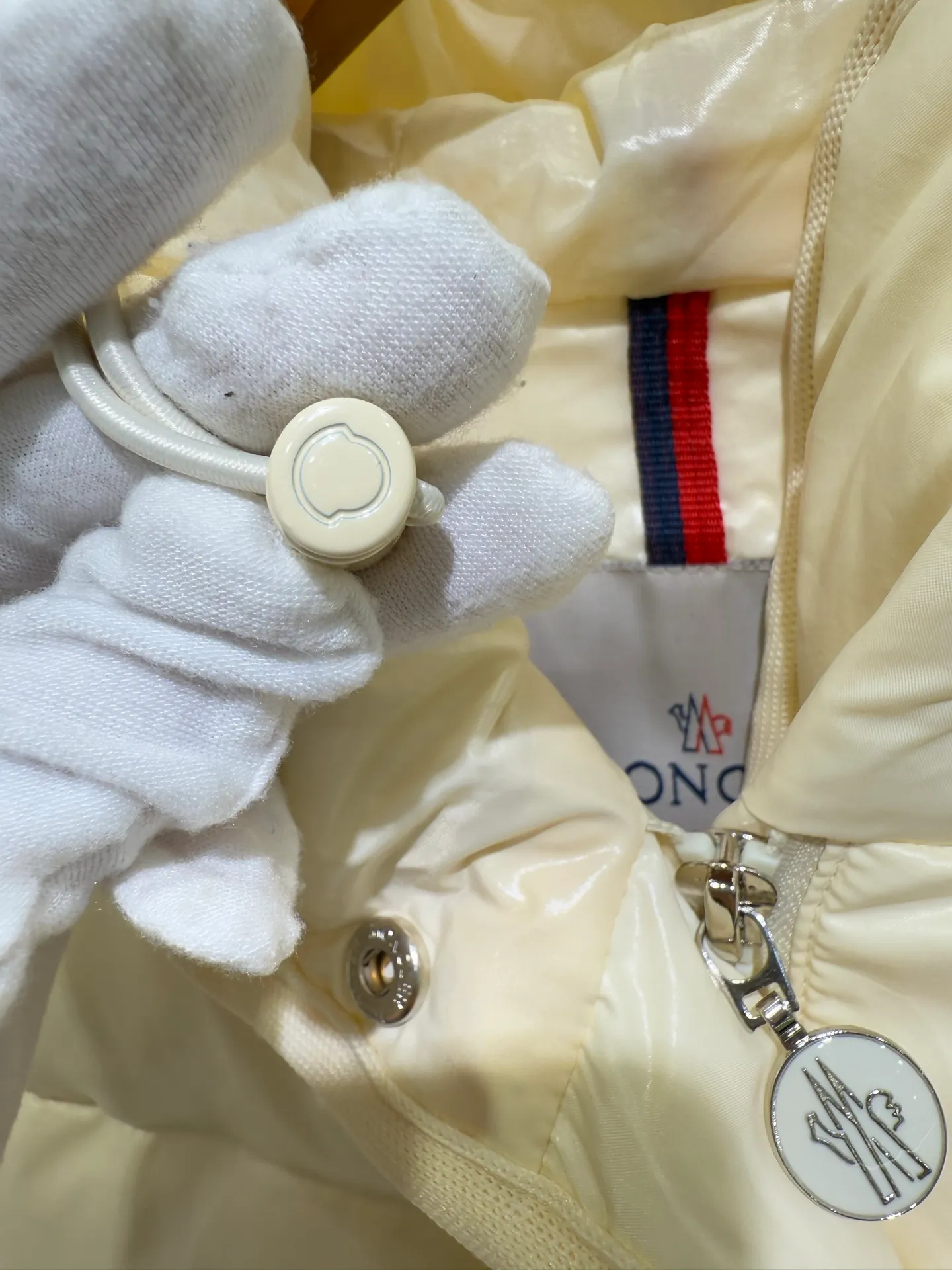 P1140 Moncler Barante series short waisted down jacket. The Barante down jacket is made of glossy nylon fabric and is inspired by the 1970s. The short version features a nipped-in waist and an A-line silhouette, highlighting a feminine style. An adjustable hood and signature logo patch add finishing touches.  Fabric: Made of nylon laque fabric, Nylon laque lining, filled with down (90 white goose down) Craftsmanship: Adjustable hood, zipper and snap closure, zipper pocket Adjustable cuffs (supports NFC function Color: black pink off-white Size: 0 1 2 3 4446080