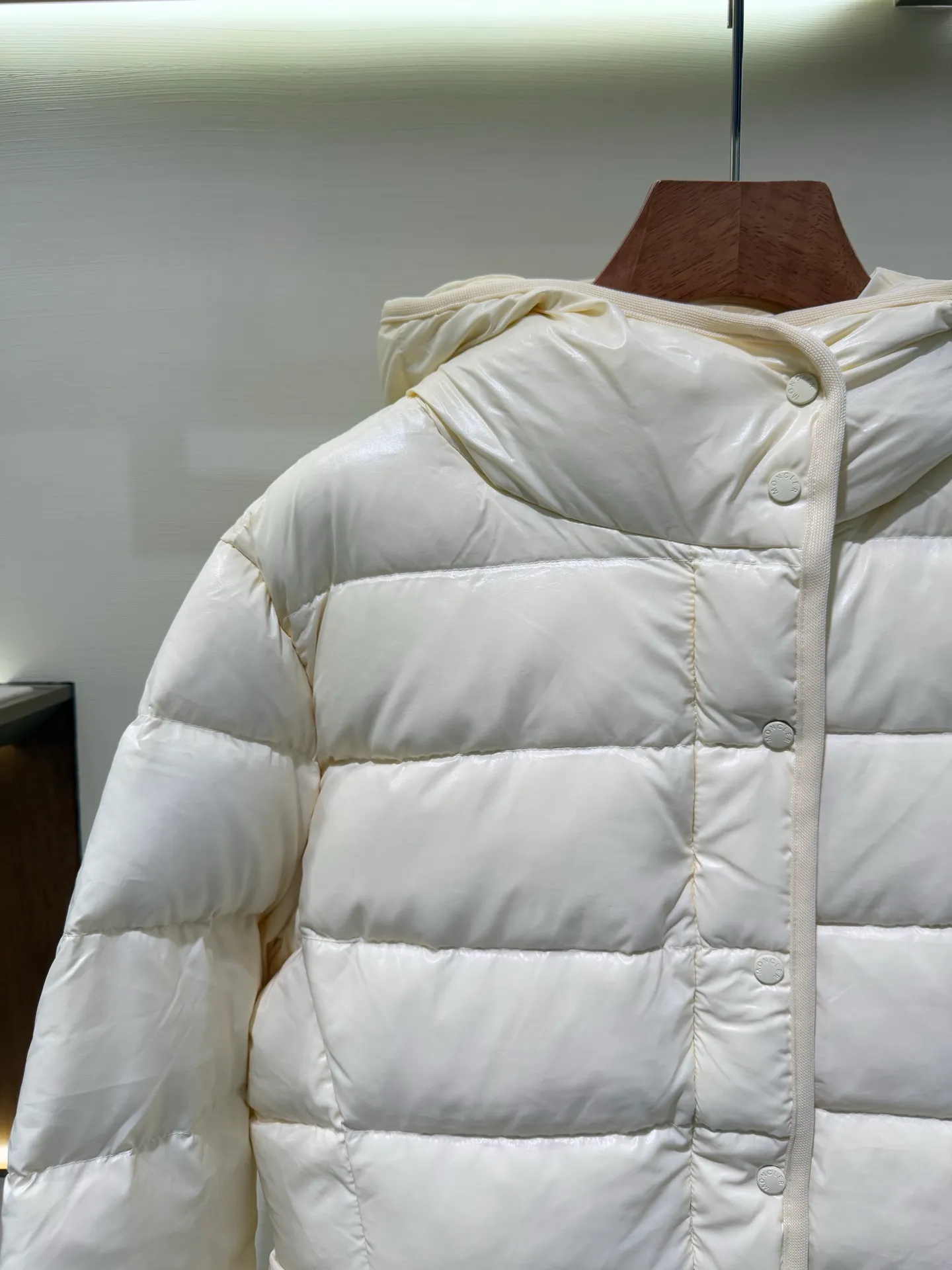 P1140 Moncler Barante series short waisted down jacket. The Barante down jacket is made of glossy nylon fabric and is inspired by the 1970s. The short version features a nipped-in waist and an A-line silhouette, highlighting a feminine style. An adjustable hood and signature logo patch add finishing touches.  Fabric: Made of nylon laque fabric, Nylon laque lining, filled with down (90 white goose down) Craftsmanship: Adjustable hood, zipper and snap closure, zipper pocket Adjustable cuffs (supports NFC function Color: black pink off-white Size: 0 1 2 3 4446080