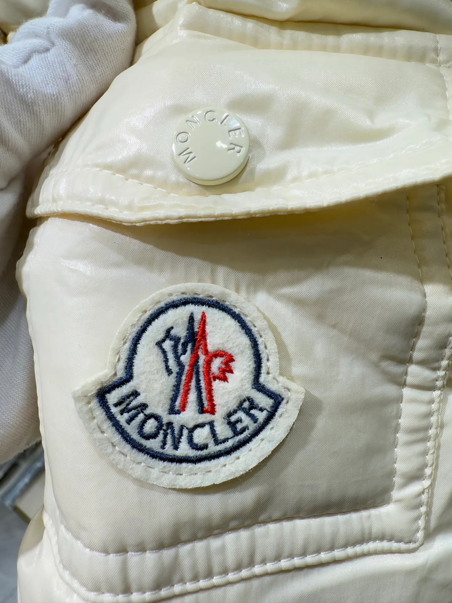 P1140 Moncler Barante series short waisted down jacket. The Barante down jacket is made of glossy nylon fabric and is inspired by the 1970s. The short version features a nipped-in waist and an A-line silhouette, highlighting a feminine style. An adjustable hood and signature logo patch add finishing touches.  Fabric: Made of nylon laque fabric, Nylon laque lining, filled with down (90 white goose down) Craftsmanship: Adjustable hood, zipper and snap closure, zipper pocket Adjustable cuffs (supports NFC function Color: black pink off-white Size: 0 1 2 3 4446080
