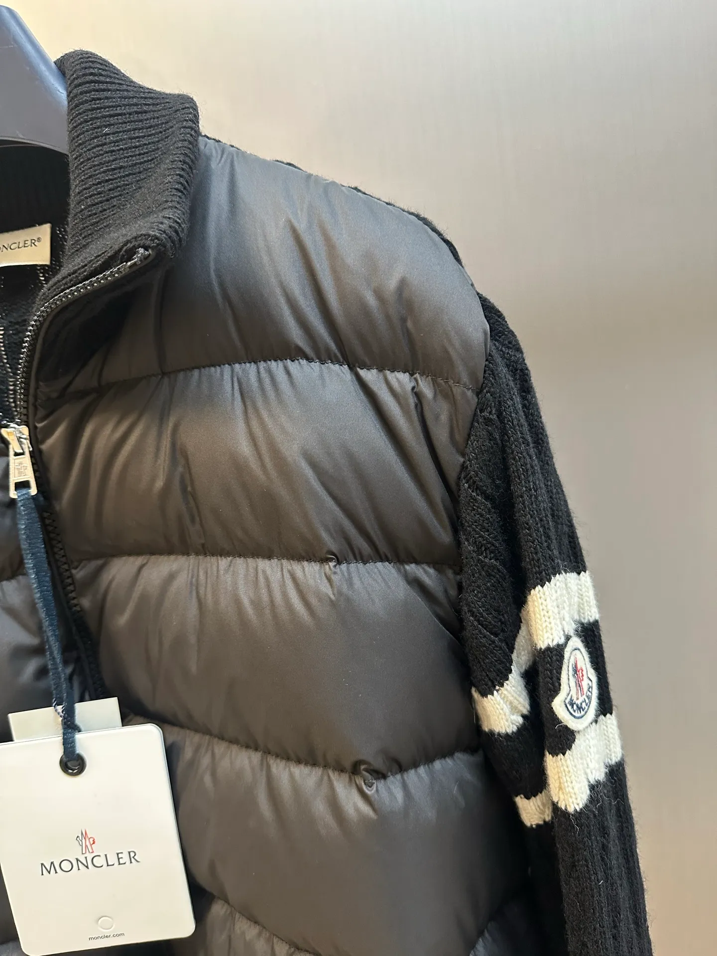 P770 Moncler Wool Spliced ​​Down Jacket The outer front fabric is made of 100% nylon (nylon). Its high-density structure achieves excellent windproof effect. It also has strong wear resistance and wrinkle resistance. It is scratch-free for daily wear and can be easily taken care of. The splicing design of sweaters and down jackets not only retains the thermal performance of down jackets, but also incorporates the fashion elements of sweaters, making the overall garment both practical and fashionable.  Filled with high-quality white duck down, with a filling capacity of 100g, it has excellent thermal insulation effect. At the same time, the sweater is made of wool, cashmere and other natural fibers, which are soft, comfortable and skin-friendly. The sweaters and down jackets are carefully spliced ​​to ensure comfortable wearing and are not prone to threading or velvet loss.  The high collar design not only provides excellent thermal insulation effect, but also adds a unique sense of fashion, allowing the wearer to maintain style in the cold season. The stripes on the sleeve arms are like bright brush strokes, embellished on the dark gray down jacket, injecting vitality and movement into the overall look, making the clothing more eye-catching.  size: 1.2.3.4