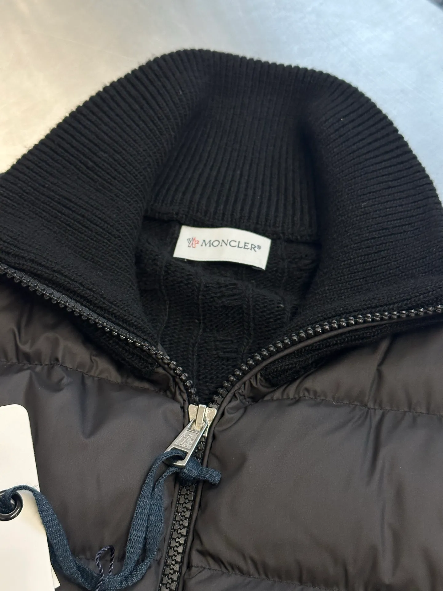 P770 Moncler Wool Spliced ​​Down Jacket The outer front fabric is made of 100% nylon (nylon). Its high-density structure achieves excellent windproof effect. It also has strong wear resistance and wrinkle resistance. It is scratch-free for daily wear and can be easily taken care of. The splicing design of sweaters and down jackets not only retains the thermal performance of down jackets, but also incorporates the fashion elements of sweaters, making the overall garment both practical and fashionable.  Filled with high-quality white duck down, with a filling capacity of 100g, it has excellent thermal insulation effect. At the same time, the sweater is made of wool, cashmere and other natural fibers, which are soft, comfortable and skin-friendly. The sweaters and down jackets are carefully spliced ​​to ensure comfortable wearing and are not prone to threading or velvet loss.  The high collar design not only provides excellent thermal insulation effect, but also adds a unique sense of fashion, allowing the wearer to maintain style in the cold season. The stripes on the sleeve arms are like bright brush strokes, embellished on the dark gray down jacket, injecting vitality and movement into the overall look, making the clothing more eye-catching.  size: 1.2.3.4