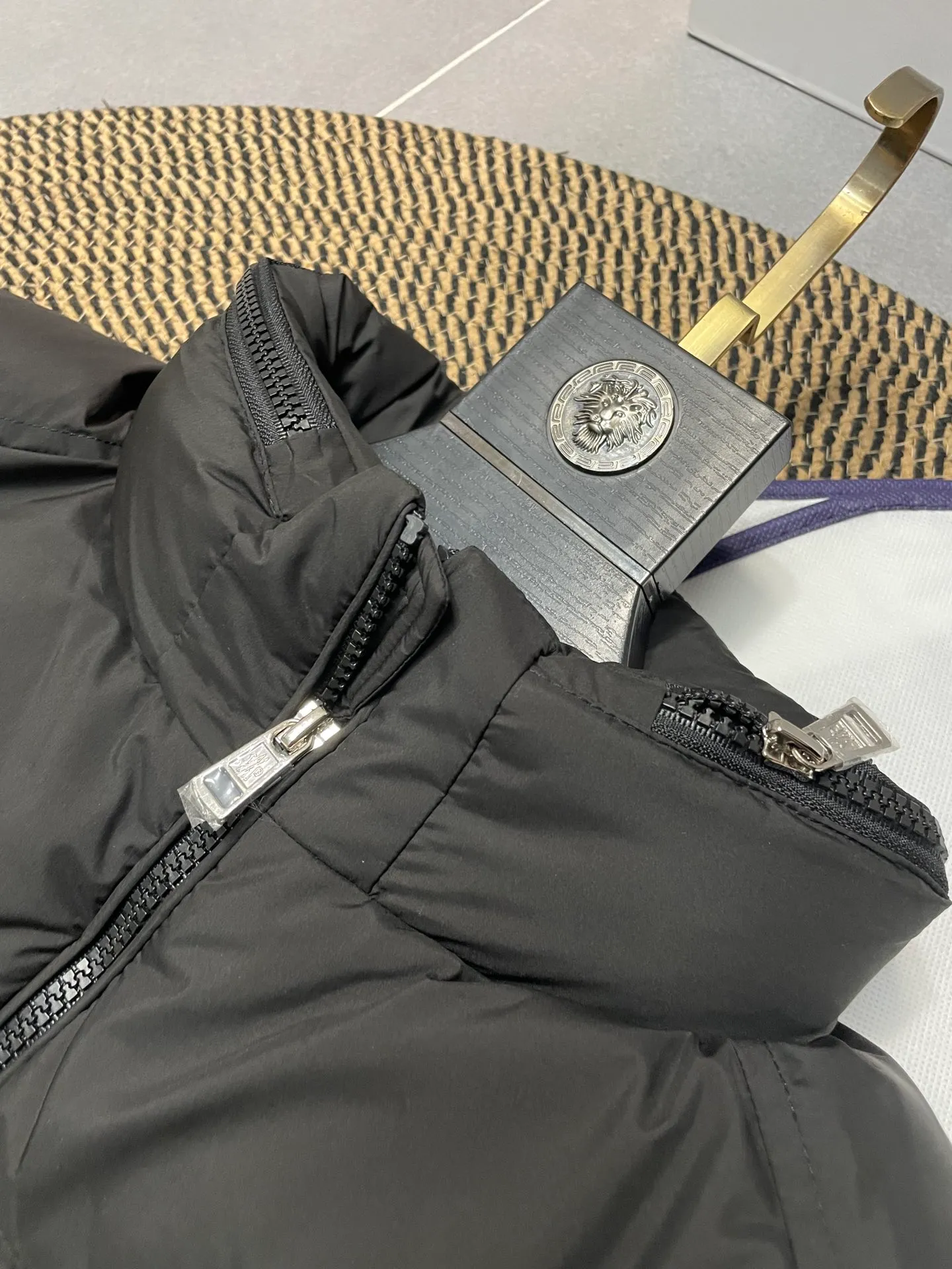 P840 🆕❤️2️⃣0️⃣2️⃣4️⃣🆕Premium down⬆️Moncler Solayan men's three-color trim short down jacket. Premium goose down filling. The finest, lightest and neatest fabric. Solayan men's short down jacket is decorated with seasonal iconic stripe details, blending sportsmanship and timeless style.  The Solayan down jacket is made of micro chic fabric and has a tough square shape design, highlighting Moncler's sporty spirit. This cropped down jacket features tricolor stripes on the sleeves, a seasonal take on the brand's signature. Comes with a practical pull-out hood. Details •Made from micro chic nylon fabric •Micro chic nylon lining •Down filled •Pull-out hood •Zip closure •Zip pockets •Adjustable cuffs •Elastic drawstring hem •Tri-color trim on sleeves Size: 1-5 Color: White Dark Brown Black