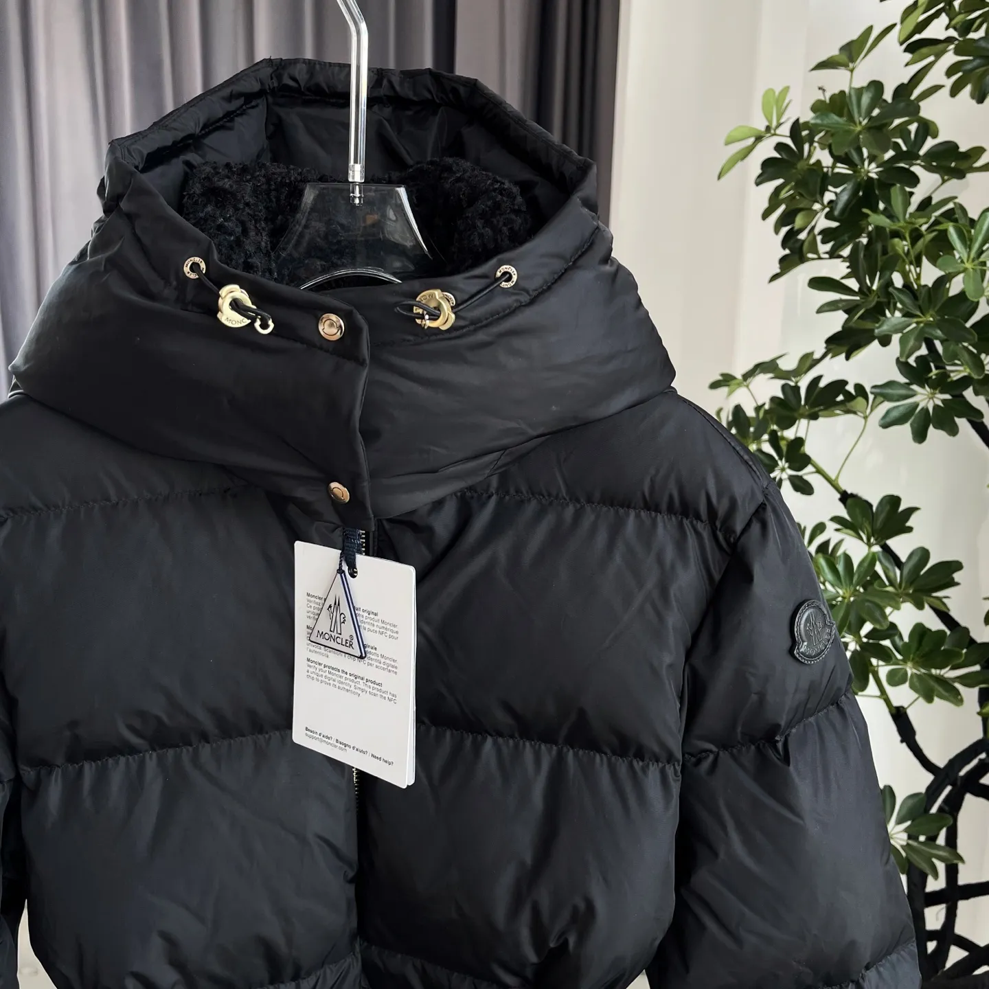 P1120 Moncler Briant Women's Hooded Long Waisted Down Jacket Jacket The Briant down jacket is designed to be both practical and comfortable to meet daily needs. Functional nylon fabric combined with a removable hood makes it easy to adapt to changing weather. This warm piece's wrap silhouette can be transformed from practical to sophisticated by adding a feminine touch with a detachable belt. The teddy velvet style collar design highlights the gentle style. Color: Black Size: 0/1/2/3