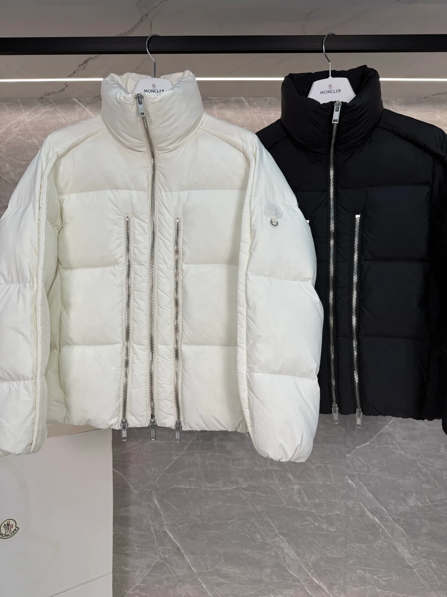 P1140 ⬆️ MONCLER GENIUS (Sky City Show Style) Moncler x Willow Smith YAEL Short Women's Down Jacket Jayel short down jacket is embellished with eye-catching metal accessories, highlighting the punk aesthetic of the Moncler x Willow Smith women's series.  The Moncler x Willow Smith Jayel down jacket features an extra zipper on the front, reinterpreting a signature punk detail. These functional zippers can be opened or closed and are reminiscent of artist-inspired vintage details. Made from nylon fabric that combines Moncler's heritage with Willow Smith's aesthetic, the metal ring on the logo patch is inspired by the artist's nose ring. Moncler Genius is a warm piece with a short and wide design that can be easily matched with the same color items in the series. Details Made of lightweight nylon Longue saison lining Filled with down Zip closure Snap pockets Adjustable cuffs and hem Embroidered logo patch with hoop Size: 0-3 White Black (Fairy Style)