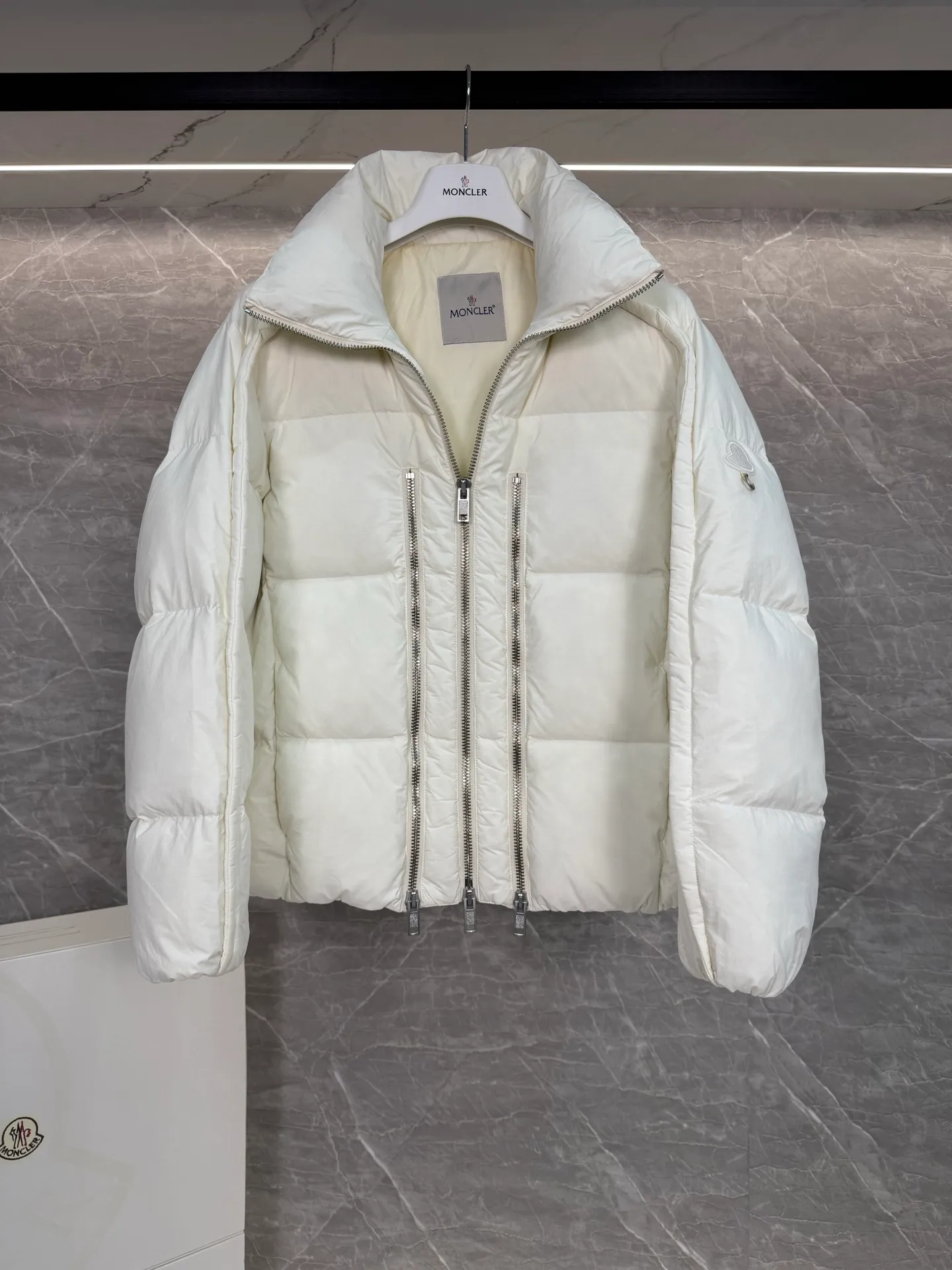 P1140 ⬆️ MONCLER GENIUS (Sky City Show Style) Moncler x Willow Smith YAEL Short Women's Down Jacket Jayel short down jacket is embellished with eye-catching metal accessories, highlighting the punk aesthetic of the Moncler x Willow Smith women's series.  The Moncler x Willow Smith Jayel down jacket features an extra zipper on the front, reinterpreting a signature punk detail. These functional zippers can be opened or closed and are reminiscent of artist-inspired vintage details. Made from nylon fabric that combines Moncler's heritage with Willow Smith's aesthetic, the metal ring on the logo patch is inspired by the artist's nose ring. Moncler Genius is a warm piece with a short and wide design that can be easily matched with the same color items in the series. Details Made of lightweight nylon Longue saison lining Filled with down Zip closure Snap pockets Adjustable cuffs and hem Embroidered logo patch with hoop Size: 0-3 White Black (Fairy Style)