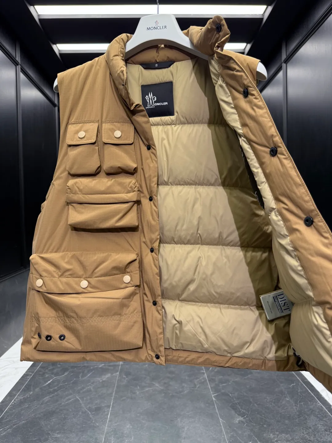 P820 ​​Premium Down ⬆️Moncler Grenoble Tongass Down Outdoor Vest. High-end Black Label Series. Original replacement fabric. Premium duck neck down filling. The Tongass Down Vest provides protection without being heavy and is specially designed for outdoor activities in mild weather.  The Tongass down vest is the result of research into lightweight performance outerwear. Functional fabric is tight and durable without adding extra weight. Features a large utility pocket and carabiner clip to reduce the amount of luggage you carry. Details •Designed for outdoor activities •Made from tight fabric •Polyester lining •Down filling •Snap button closure •Utility pockets with snap, zip and Velcro closure •Drawstring hem •Front carabiner •Reflective details Size: 1-5 Light Brown/Black D00780