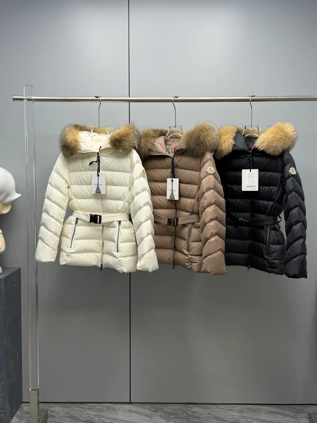 P1180 MONCLER 2025FW Women's Cupidone Large Fur Collar Small Waist Slim Belt Hooded Down Jacket Three-dimensional girdle design: innovatively uses an adjustable belt to accurately outline women's waist curves, effectively enhance the waistline, reshape the golden body proportions, and completely bid farewell to the bloated feeling of traditional down jackets. A-line micro silhouette: tall and straight upper body, slightly flared hem, elegance and agility coexist. Symbol of luxury | Oversized fur collar, choose a large fur collar: The brim of the hat is decorated with a luxurious and fluffy large fur collar, which not only provides the ultimate in warmth and care, but also demonstrates extraordinary taste and strong aura. High-quality fleece core: uniform fleece filling and temperature locking technology to ensure that it remains warm as spring in extremely cold environments. Whether paired with skinny jeans to create a casual fashion, or worn under a dress to show elegance. Color: Milky white, brown, black Size: 1-2-3-4