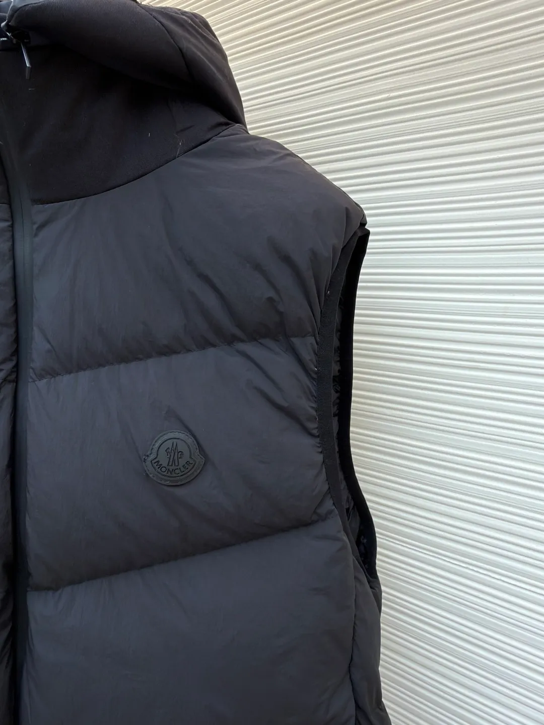 P670 MONCLER emblem hooded down vest ●Original version: purchased and developed by 6269 ●Item number: 1681645-C00 ●Fabric: white duck down fabric ●Technology: mechanical down filling ●Color: black ●Version: fitted version ●Weight: about 565 grams ●Size: 1-2-3-4 ●Description: The nylon fabric made of 100% nylon is woven into a tight and tough fabric through advanced textile technology. The strength of the frame is increased to effectively block the invasion of cold wind and lock the warm air generated by the down layer. After a tight weaving process and special treatment, it is waterproof and windproof. The surface forms a certain lotus leaf effect. It is also wrinkle-resistant and not easy to deform, making it easy for daily care. The quilting stitches are sewn in a diagonal direction at an angle of about 70 degrees, and the diagonal lines are arranged in parallel. The fabric and filling are planned into different functional areas, and the quilting stitches in each partition are relatively independent. This allows the finished product to produce a larger deformation space along the diagonal direction when stretched and pressed, making it less likely to tighten and break, and has rich visual effects, modern and advanced features. After the hood is removed, the stand-up collar displays an embossed logo of the same color, adding a unique visual experience and tactile details. Filled with 90% selected white duck down and weighing 170g, it ensures fluffiness, quick rebound, lightness and warmth. The overall wiring is straight and delicate, the fabric is comfortable and soft, and the color is consistent without color difference. It can be matched with the same style to create a fashionable look and control various occasions. Customized accessories, complete with three standards, same style for men and women!
