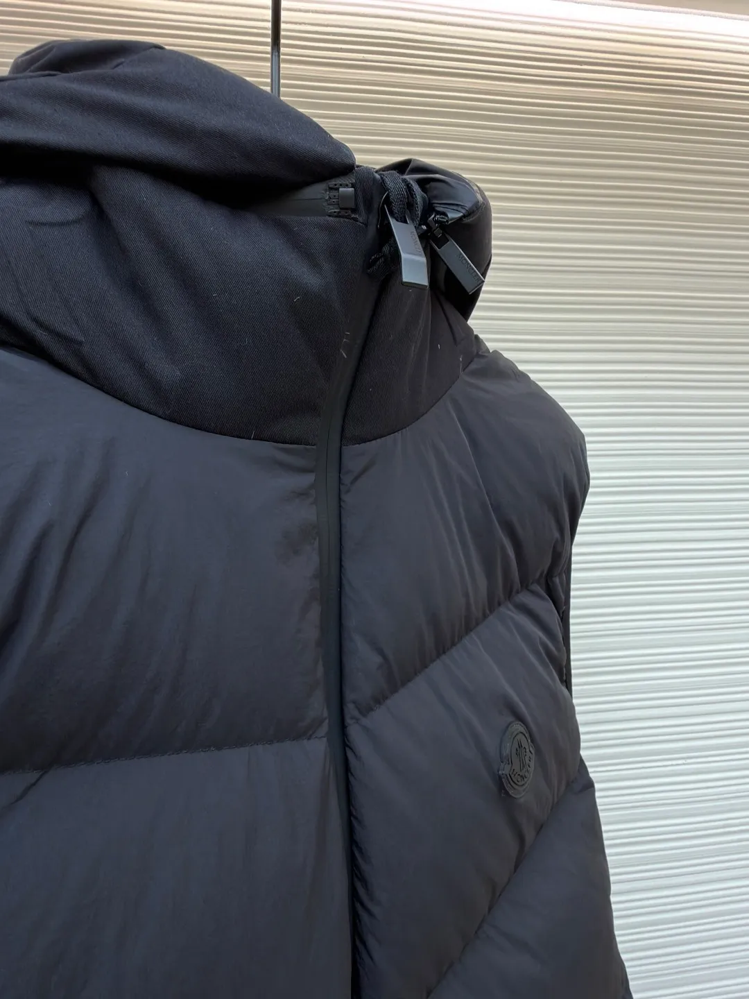 P670 MONCLER emblem hooded down vest ●Original version: purchased and developed by 6269 ●Item number: 1681645-C00 ●Fabric: white duck down fabric ●Technology: mechanical down filling ●Color: black ●Version: fitted version ●Weight: about 565 grams ●Size: 1-2-3-4 ●Description: The nylon fabric made of 100% nylon is woven into a tight and tough fabric through advanced textile technology. The strength of the frame is increased to effectively block the invasion of cold wind and lock the warm air generated by the down layer. After a tight weaving process and special treatment, it is waterproof and windproof. The surface forms a certain lotus leaf effect. It is also wrinkle-resistant and not easy to deform, making it easy for daily care. The quilting stitches are sewn in a diagonal direction at an angle of about 70 degrees, and the diagonal lines are arranged in parallel. The fabric and filling are planned into different functional areas, and the quilting stitches in each partition are relatively independent. This allows the finished product to produce a larger deformation space along the diagonal direction when stretched and pressed, making it less likely to tighten and break, and has rich visual effects, modern and advanced features. After the hood is removed, the stand-up collar displays an embossed logo of the same color, adding a unique visual experience and tactile details. Filled with 90% selected white duck down and weighing 170g, it ensures fluffiness, quick rebound, lightness and warmth. The overall wiring is straight and delicate, the fabric is comfortable and soft, and the color is consistent without color difference. It can be matched with the same style to create a fashionable look and control various occasions. Customized accessories, complete with three standards, same style for men and women!