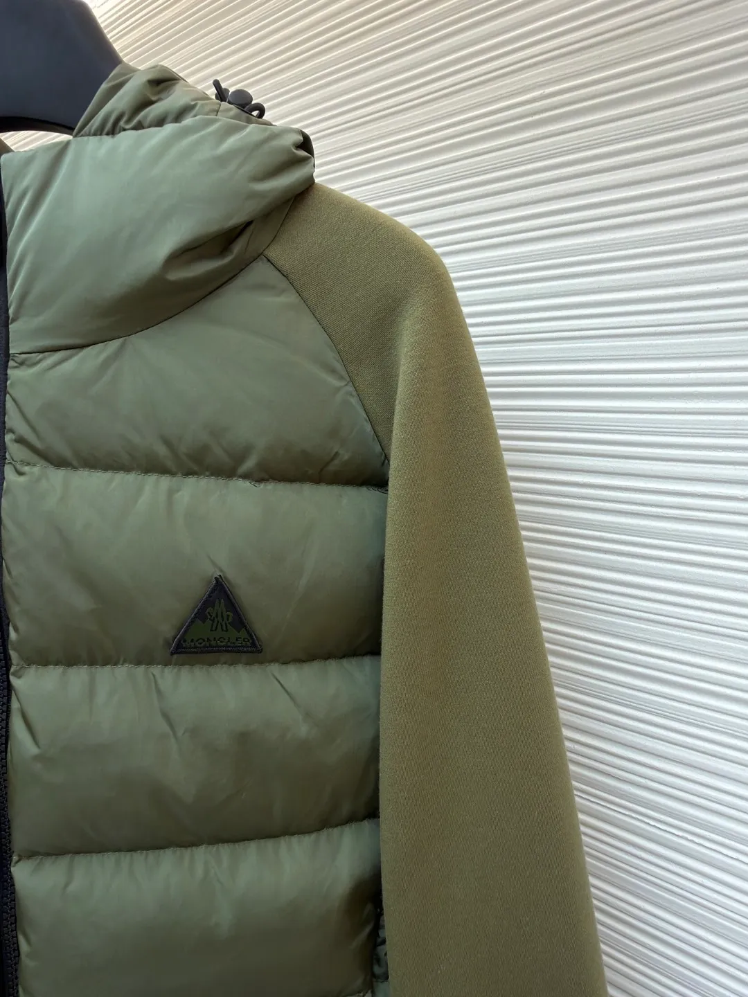 P810 Moncler logo woven splicing down jacket ●Item number: 1682128-C65 ●Material: white duck down fabric ●Technology: mechanical down filling ●Color: green ●Version: fitted version ●Weight: about 700 grams ●Size: S-M-L-XL ●Description: Customized matte lattice air shield down and 300D high-density calendered coating Use the new national standard 90 white duck down (welcome to test) Full flushing capacity Full of warmth, light and fluffy. With the dark green of the overlapping mountains as the background color, all things accumulate energy and create their own scenery in silence. The Monlcer triangle logo is embellished on the chest. The power aesthetics of the minimalist logo. The concentrated down filling in the front area creates dynamic insulation for the core heat dissipation zone of the human body. The hooded down is a moving warm flow barrier for the head and neck, forming a thermal energy circulation system with the front panel. The elastic woven sleeves provide freedom of movement with a sense of compression, forming a relaxed and warm philosophy, truly advanced. It is a mechanical down filling that allows function to become a footnote of style. Priority is given to making inner liner paper patterns to determine the down filling area and the gram weight of down per square meter according to the original three-dimensional effect, thereby calculating the filling amount of each cut piece. The computer down filling machine uses a digital weighing unit to achieve stable measurement. 3D three-dimensional quilting technology uses the programming system of the CNC quilting machine to accurately separate the down in different areas to ensure that the filling is evenly fixed after sewing. To avoid agglomeration or shifting, the template machine lines the lines. The line line process of the computer template machine shows extremely high neatness and smoothness. The craftsman accurately controls the size during the operation to ensure that each line meets the design requirements. The lines of the entire template are smooth and unified. Neat and beautiful, triple seam five-thread dense stitching process The triple structure of main seam overlocking + diagonal reinforcement + raw edge wrapping forms a three-dimensional protective net at the edge of the fabric to avoid stitch breakage. The overall wiring is straight and delicate, the fabric is comfortable and soft, and the color is consistent without color difference. It can be matched with the same style to create a fashionable look and control various occasions. Customized accessories, complete with three standards, same style for men and women!
