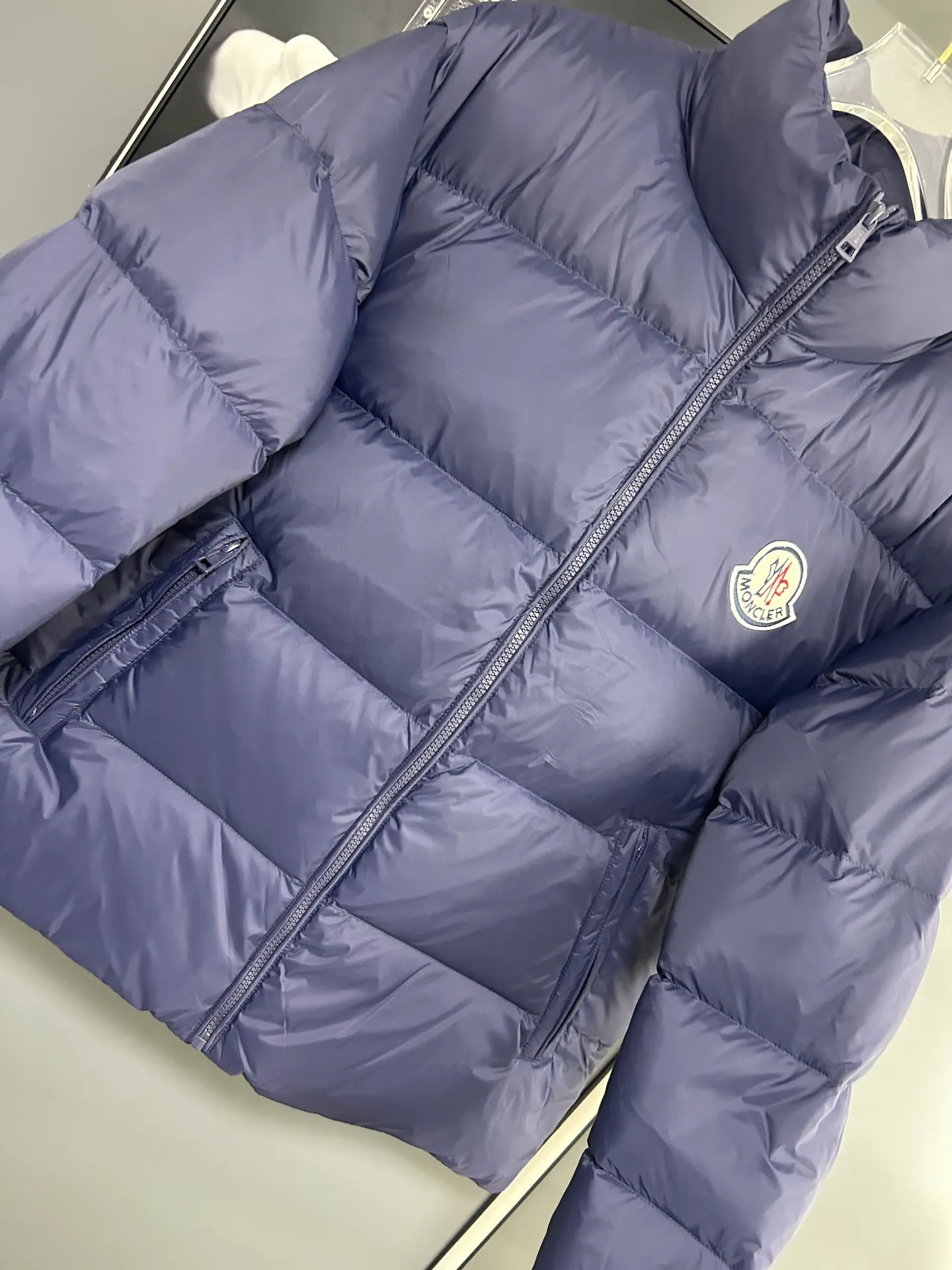 P660 Moncler Citala short men's down jacket jacket. Filled with premium European duck neck down. With a fill power of 850+, the Citala men's short down jacket is made of pop-colored lightweight fabric, highlighting the vitality of the series.  Made from lightweight nylon with a longue saison lining, the Citala down jacket is comfortable and warm without being bulky. This cropped down jacket has a comfortable fit, a signature turtleneck and a quilted, checkered silhouette. Details Made from lightweight nylon fabric, zipper closure, zippered pockets, elastic cuffs and hem Color: Navy Size: M-3XL
