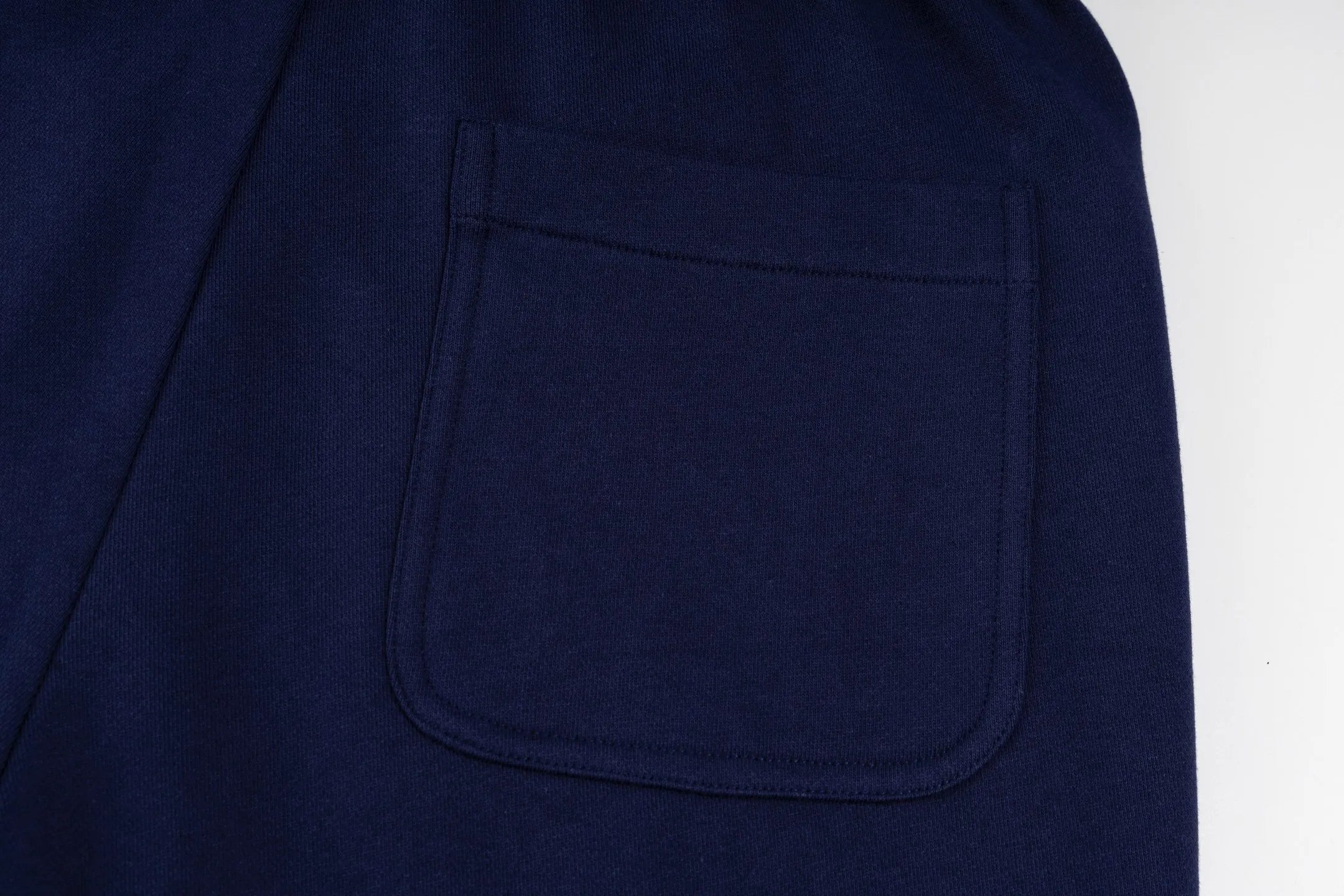 P300 [Exclusive supply] Moncler Mouthless Three-Party Joint Shorts (Navy Blue) The fabric is made of single-sided fish-scale fabric woven with cotton as the base. The front is a smooth knitted surface, and the skin-contacting surface is formed into three-dimensional terry through the floating knitting technology of the knitting machine, which increases the fluffiness and has a delicate touch. The terry structure absorbs a large amount of water and evaporates quickly, so it is not easy to loosen and deform after repeated washing. The letters LOGO are embroidered on the back panel using 16,000 needles + 18,000 needles on the embroidery machine. The double-axis linear guide drives the embroidery frame, and the frame moving accuracy can reach 0.01mm/P, ensuring precise positioning of the embroidery pattern. By actively interfering with the shrinkage potential of cotton fibers, the fabric is able to transition from changeable to stable, improving dimensional stability while being less prone to deformation and wrinkles. Size:S-M-L-XL