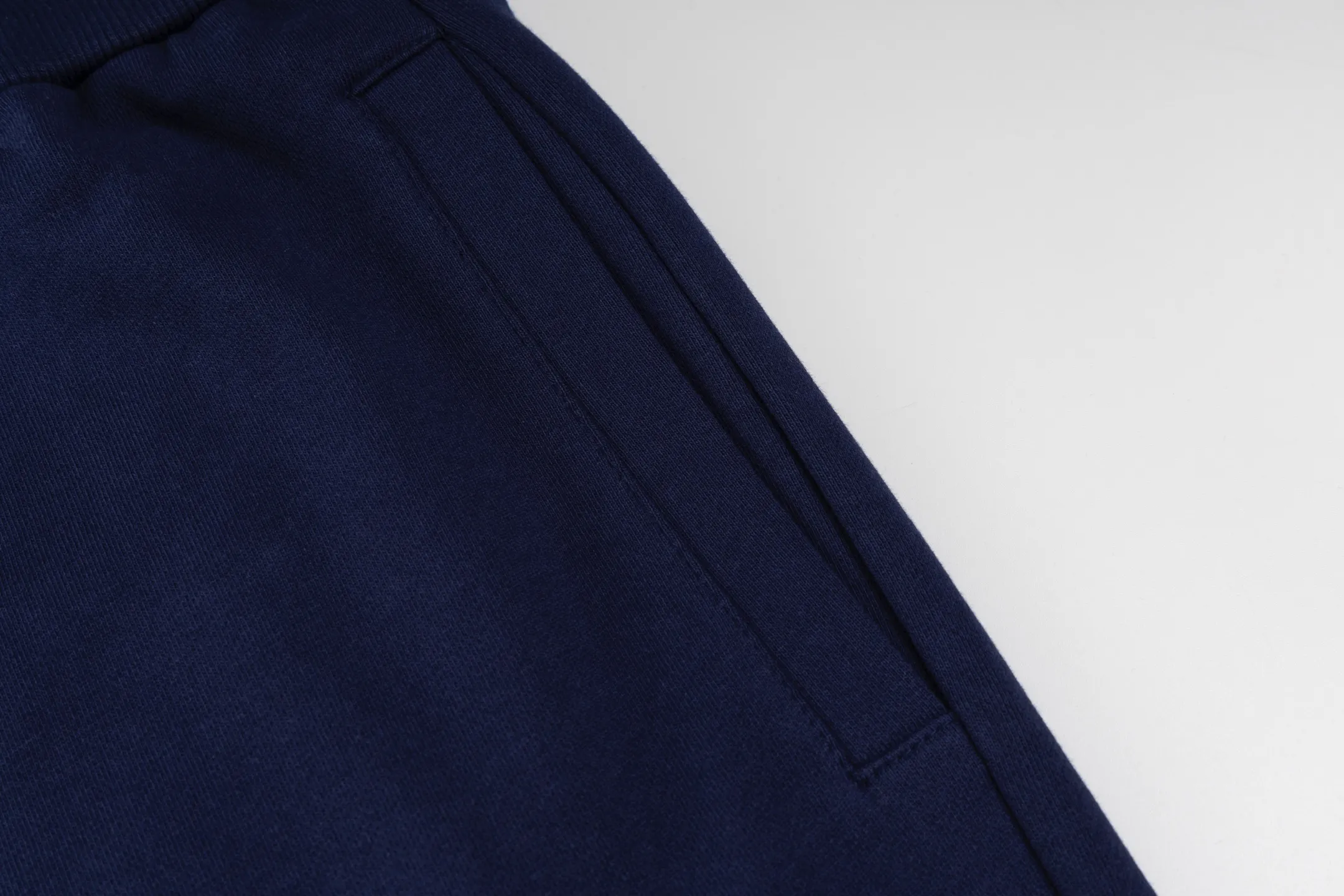 P300 [Exclusive supply] Moncler Mouthless Three-Party Joint Shorts (Navy Blue) The fabric is made of single-sided fish-scale fabric woven with cotton as the base. The front is a smooth knitted surface, and the skin-contacting surface is formed into three-dimensional terry through the floating knitting technology of the knitting machine, which increases the fluffiness and has a delicate touch. The terry structure absorbs a large amount of water and evaporates quickly, so it is not easy to loosen and deform after repeated washing. The letters LOGO are embroidered on the back panel using 16,000 needles + 18,000 needles on the embroidery machine. The double-axis linear guide drives the embroidery frame, and the frame moving accuracy can reach 0.01mm/P, ensuring precise positioning of the embroidery pattern. By actively interfering with the shrinkage potential of cotton fibers, the fabric is able to transition from changeable to stable, improving dimensional stability while being less prone to deformation and wrinkles. Size:S-M-L-XL