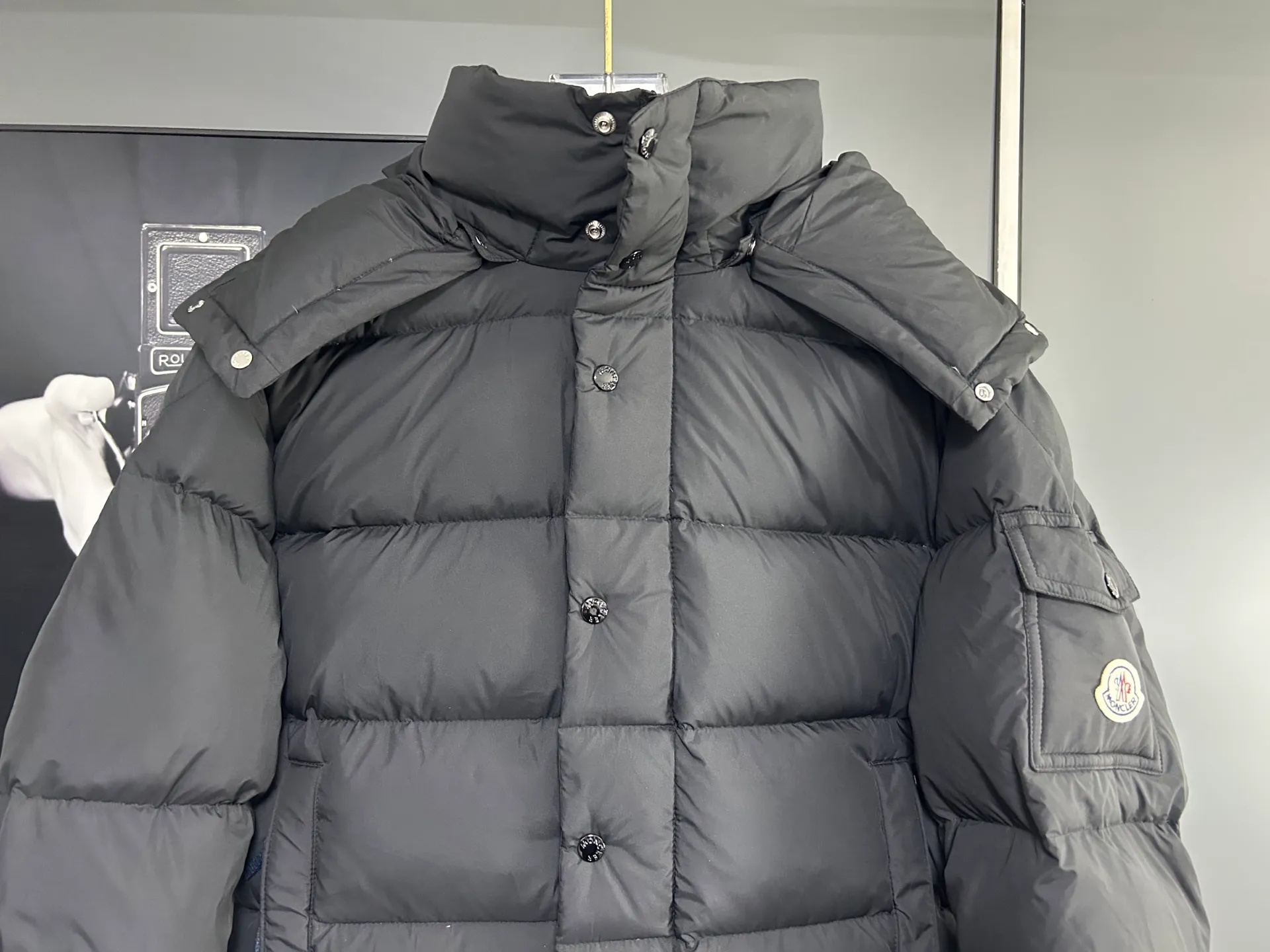 P840 MONCLER matte Maya down jacket. Process description: Made of the brand's iconic longue saison fabric, it has both light texture and excellent thermal insulation performance. This unisex down jacket has a matte appearance and is lined with lon léger brillant material to ensure comfort. Its core filling is 90% high-quality goose down, with a down filling capacity of 204 grams, providing excellent thermal insulation effect. The design continues the classic elements of Moner, with the short silhouette and sleeve patch pocket details paying tribute to the Maya series. In terms of functionality, it is equipped with a detachable and adjustable hood, a dual zipper and snap button opening system, and a zipper pocket to enhance practicality. The sleeves are specially designed with adjustable cuffs and a drawstring hem design, so you can freely adjust the tightness according to your needs. The overall craftsmanship is exquisite, which not only retains Moner's consistent fashion genes, but also enhances the convenience of daily wear through exquisite detail processing. ⚠️Color: Black ⚠️Size: 12345