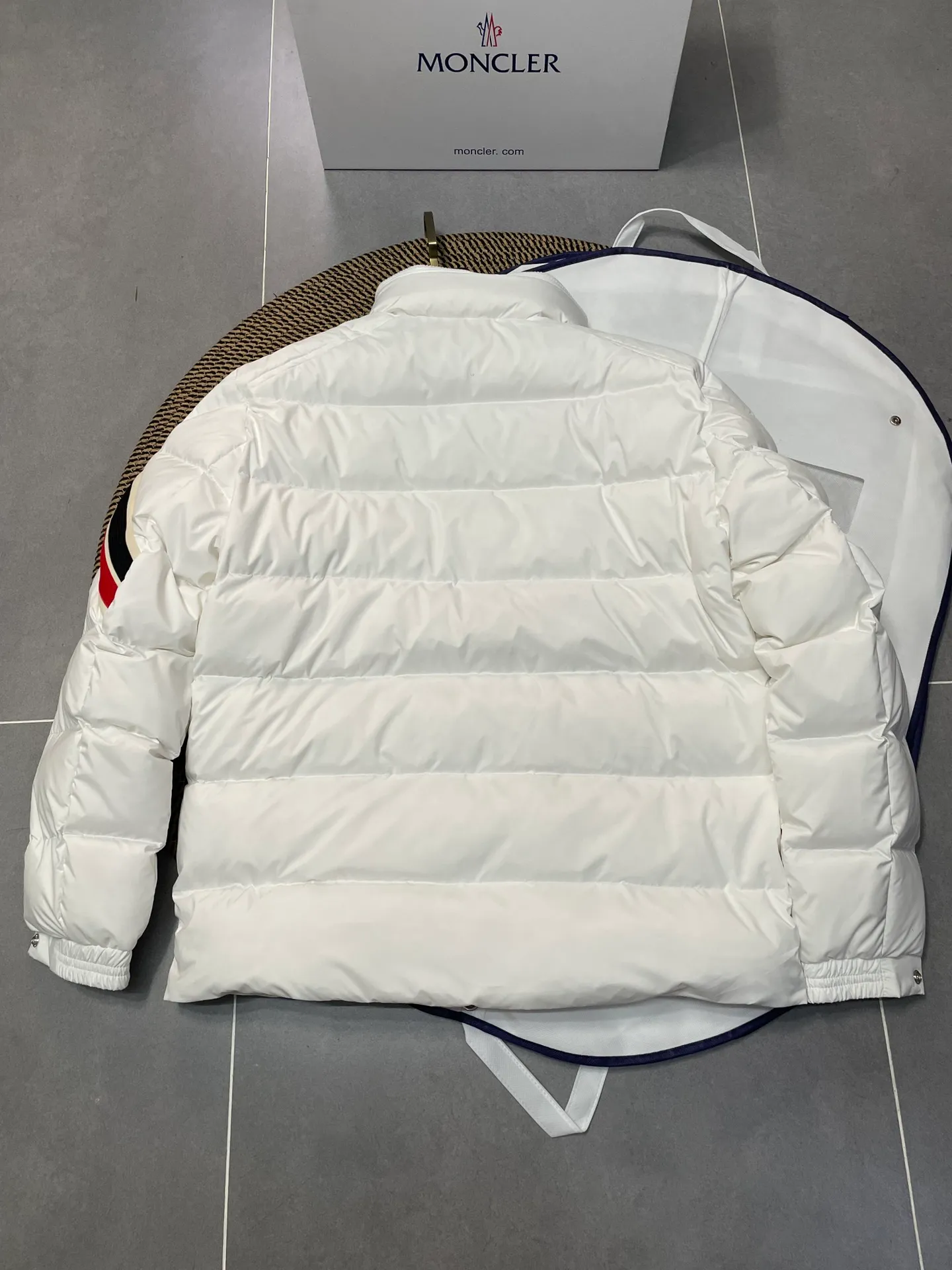 P840 🆕❤️2️⃣0️⃣2️⃣4️⃣🆕Premium down⬆️Moncler Solayan men's three-color trim short down jacket. Premium goose down filling. The finest, lightest and neatest fabric. Solayan men's short down jacket is decorated with seasonal iconic stripe details, blending sportsmanship and timeless style.  The Solayan down jacket is made of micro chic fabric and has a tough square shape design, highlighting Moncler's sporty spirit. This cropped down jacket features tricolor stripes on the sleeves, a seasonal take on the brand's signature. Comes with a practical pull-out hood. Details •Made from micro chic nylon fabric •Micro chic nylon lining •Down filled •Pull-out hood •Zip closure •Zip pockets •Adjustable cuffs •Elastic drawstring hem •Tri-color trim on sleeves Size: 1-5 Color: White Dark Brown Black