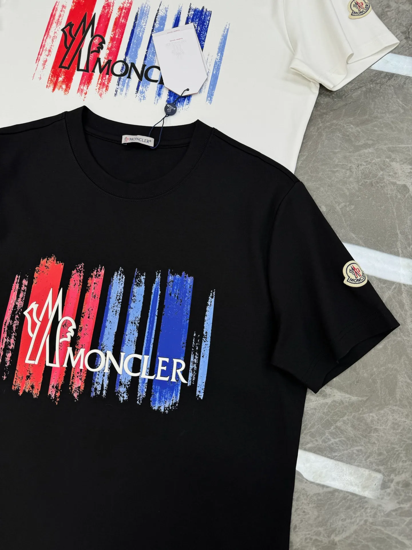 P160 Moncler 25s new modal T-shirt. Brand letter logo printing design. Graffiti shape. Red and blue color gradient combination presents special features. Classic small hat at the cuff position. Clean, refreshing, simple and generous. Recommended items for any age [Fireworks] regular version! Custom-made 250g modal comb fabric, the surface is skin-friendly and smooth, and the body is as comfortable as a baby! Color: Black. White. Size: s-xxl