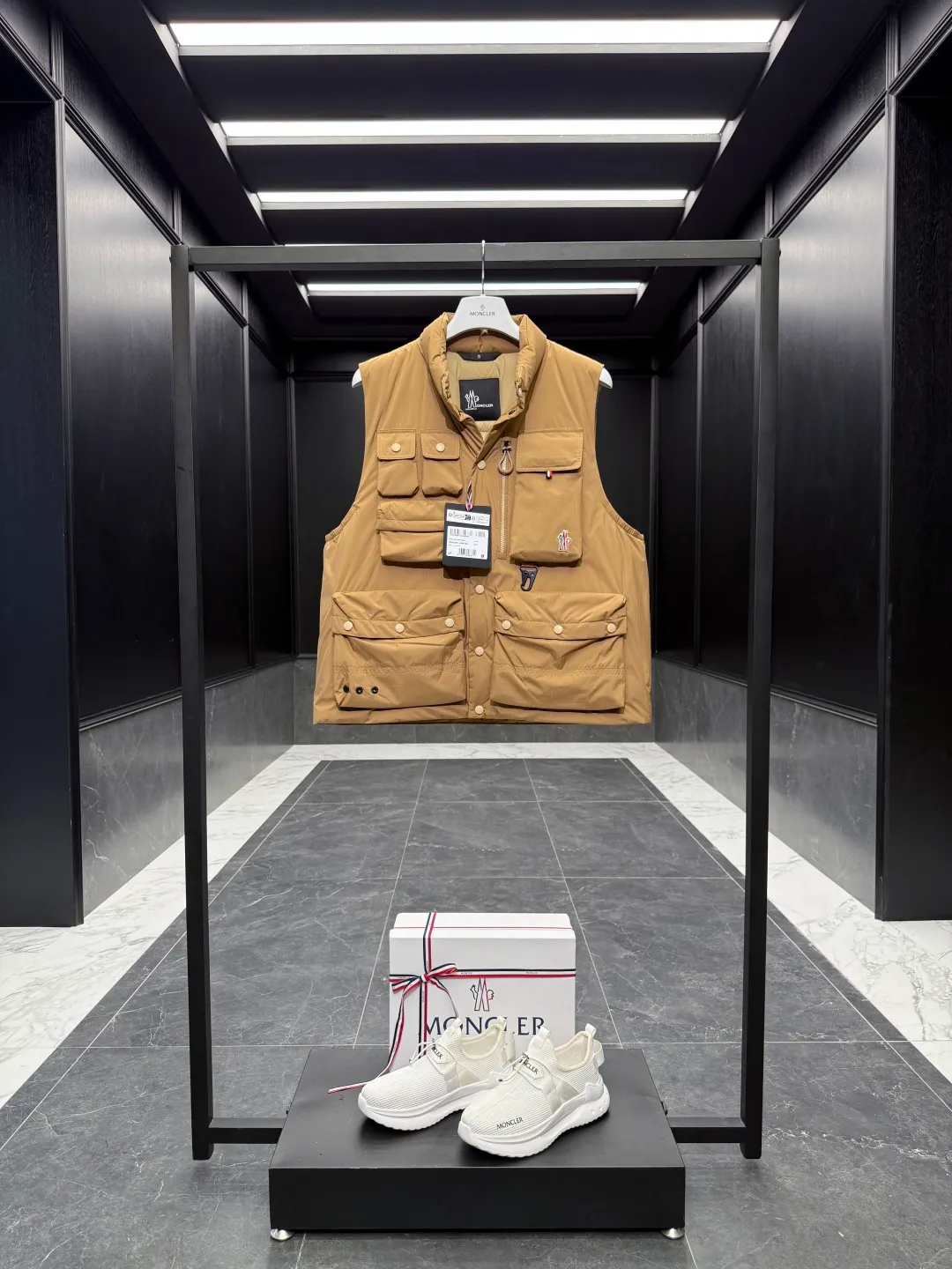 P860 Premium Down⬆️Moncler Grenoble Tongass Down Outdoor Vest. High-end Black Label Series. Original replacement fabric. Premium gooseneck filling. 🎁 Comes standard with a full set of counter gift box packaging. Upgraded original magnetic gift box. The Tongass Down Vest provides protection without being heavy, and is specially designed for outdoor activities in mild weather.  The Tongass down vest is the result of research into lightweight performance outerwear. Functional fabric is tight and durable without adding extra weight. Features a large utility pocket and carabiner clip to reduce the amount of luggage you carry. Details •Designed for outdoor activities •Made from tight fabric •Polyester lining •Down filling •Snap button closure •Utility pockets with snap, zip and Velcro closure •Drawstring hem •Front carabiner •Reflective details Size: 1-5 Cream/Light Brown/Black D00780