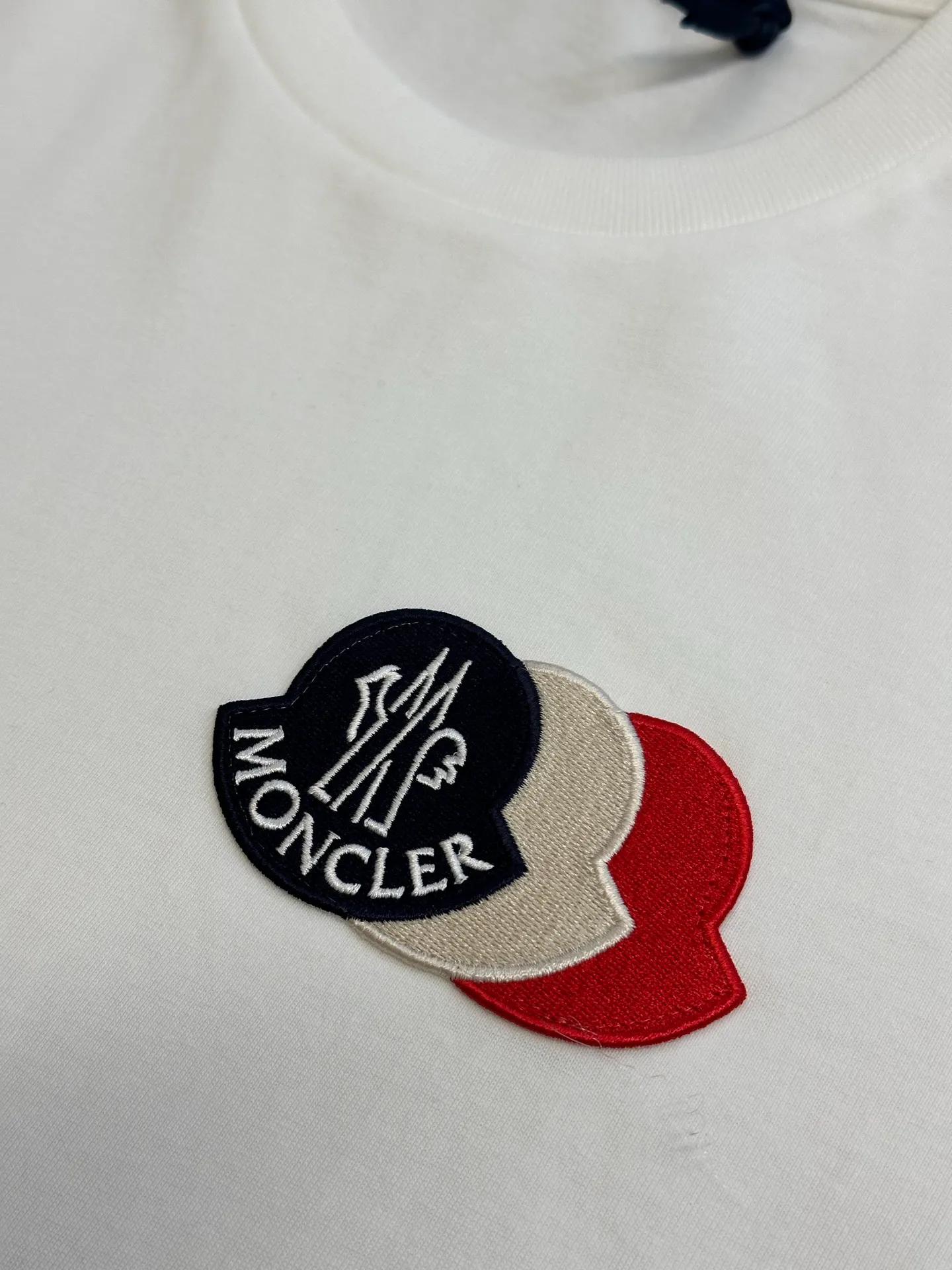 P230 Moncler short-sleeved patch logo, custom-made cloud-soft plain cotton fabric, with the iconic three-color design badge embellished on the chest, interpreting the visual grammar of modern luxury, and the Moncler embroidered logo on the side, highlighting the brand style.  Using imported machine embroidery technology, advanced computer control systems and precision mechanical components, Moncler embroidery logo embroidery operations are realized.  size：s m l xl