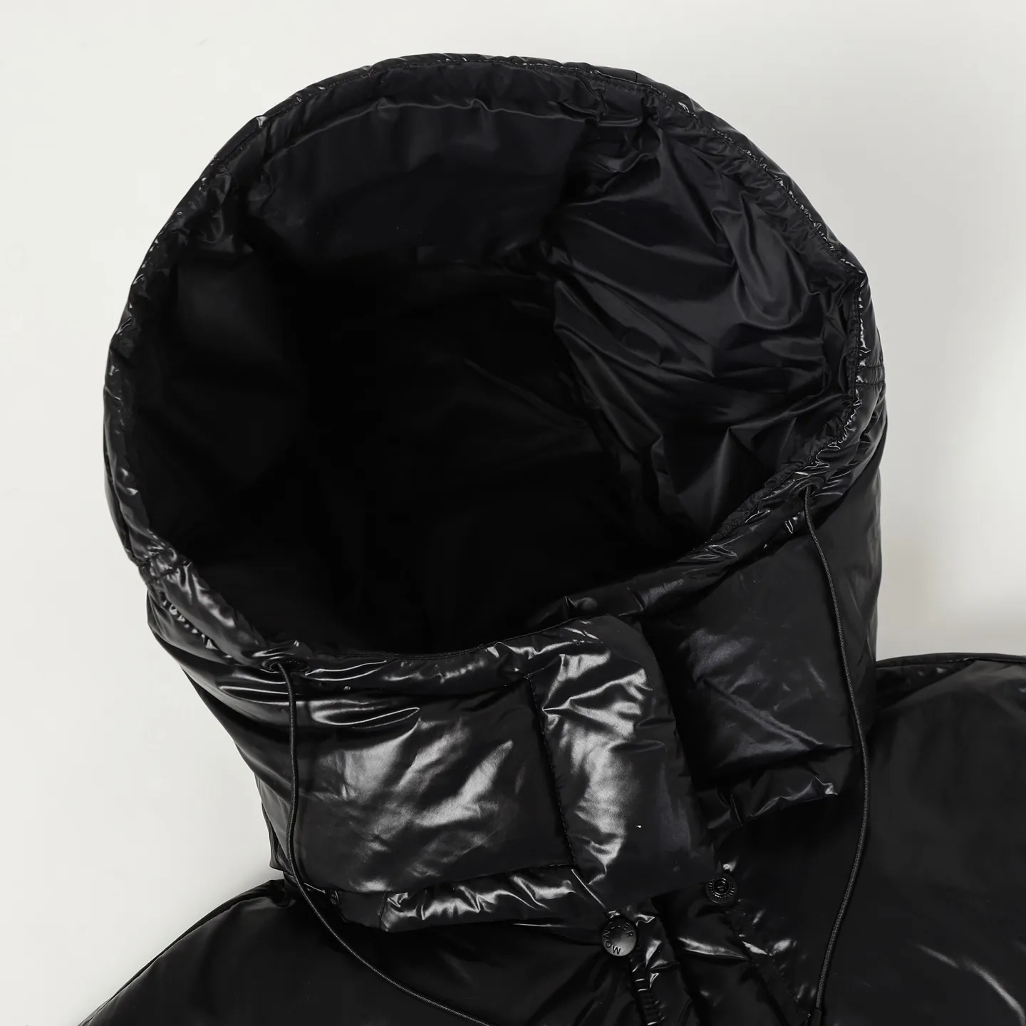 P920 Moncler/Meng Mouth Women's Square Quilted Hooded Short Down Jacket Fabric selection: Selected high-density super laqué nylon fabric, matched with lightweight down filling, and nylon lining design, which ensures excellent thermal performance while showing an avant-garde urban style.  Craftsmanship and details: The short silhouette is paired with innovative super laqué nylon fabric, which presents a unique glossy texture and perfectly blends functionality and fashion. Breakthrough asymmetrical tailoring, with double-button closure system. Three-dimensional geometric quilting technology, creating visual hierarchy through differentiated quilting sizes on the body and sleeves. Detachable and adjustable hood design to meet various dressing needs. Double closure system (zipper + snap button) ensures windproof and warm. Multifunctional storage space: zipper security pocket + snap-button chest pocket. Drawstring hem design, the tightness can be adjusted freely. 90 national standard high-quality white duck down: Selected high-loft down, weighing 210g, light and warm, with excellent temperature locking performance and good resilience.  Accessories: Customized armband Customized snap button Customized zipper puller Color: black/beige/green SIZE: 1/2/3/4